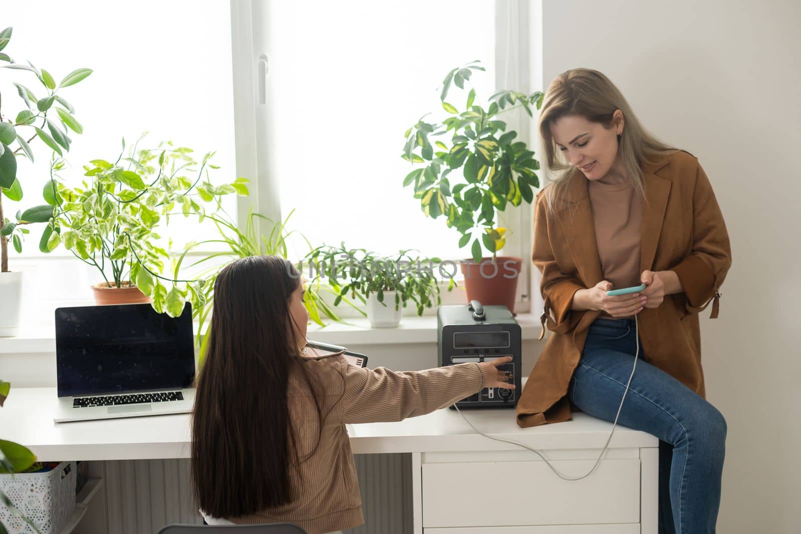 mother and daughter use a portable charging station.