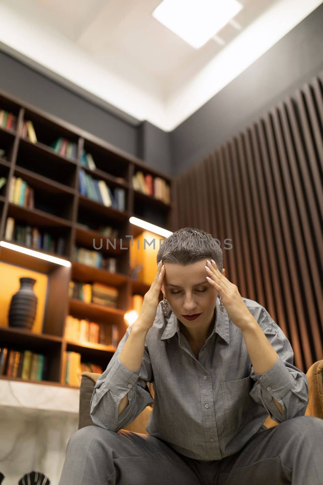 stylish caucasian woman holding her hands behind her head in thought.