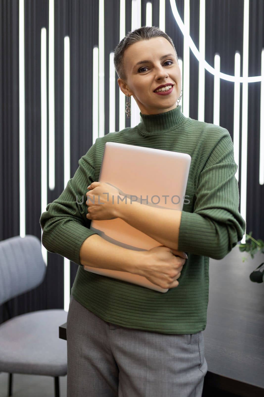 portrait of a successful mature female programmer against the backdrop of a stylish office.