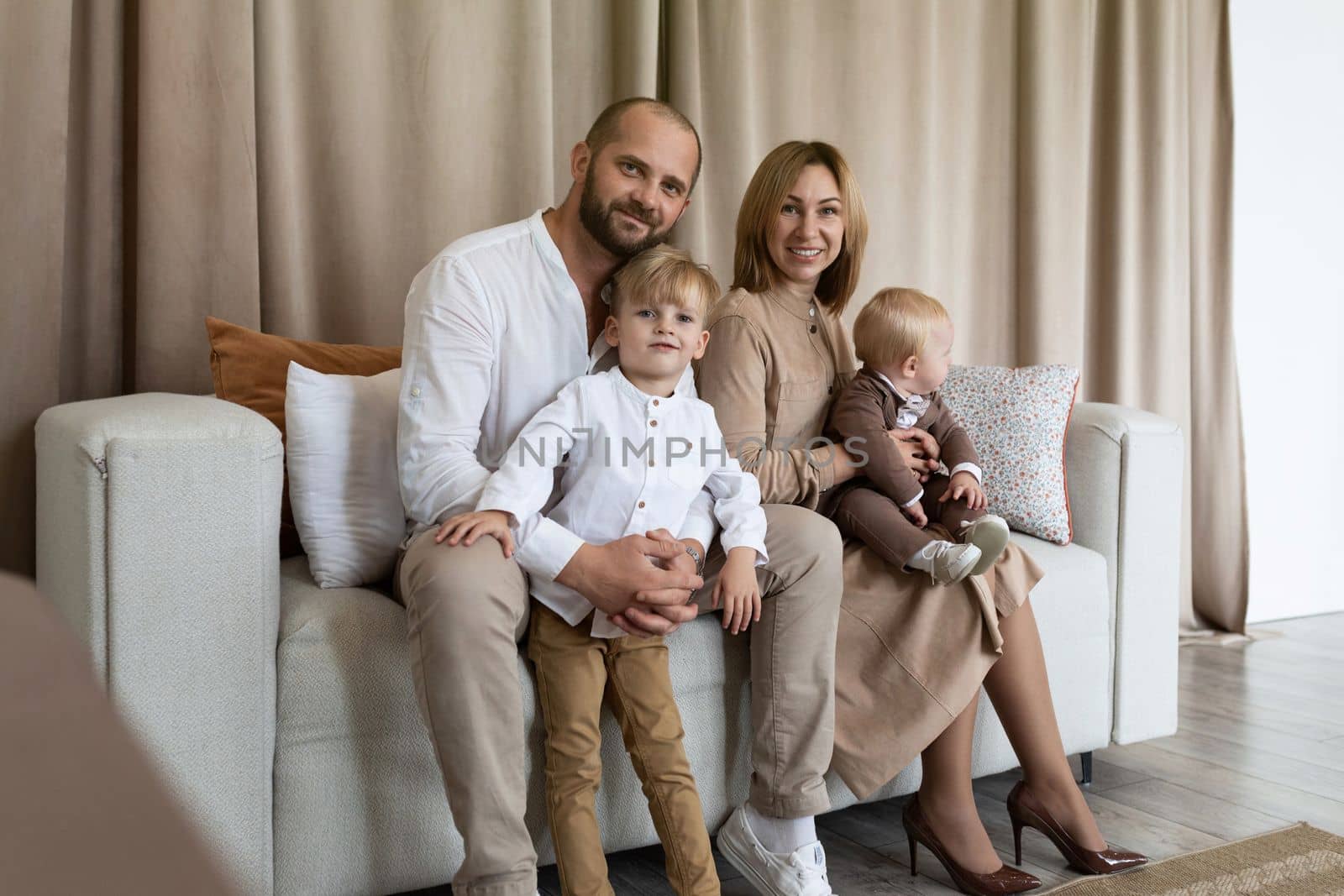 portrait of a stylish young family with two male children.