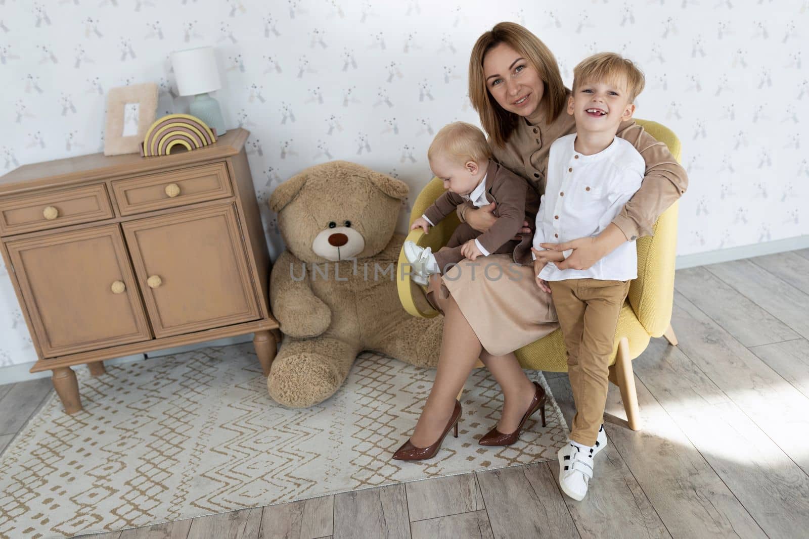 happy mom with two male children in the children's room having fun.