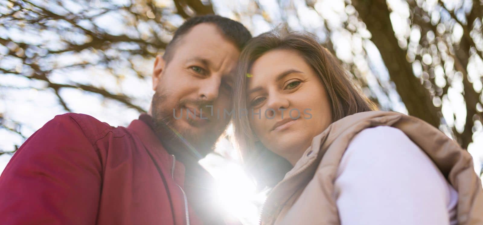 close-up portrait of a married couple in love husband and wife looking down at the camera by TRMK
