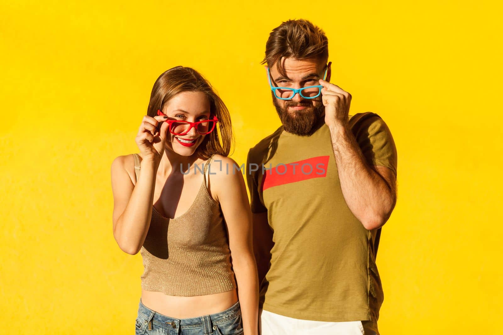 Couple having fun together, spending happy time together, holding frame of colorful glasses. by Khosro1