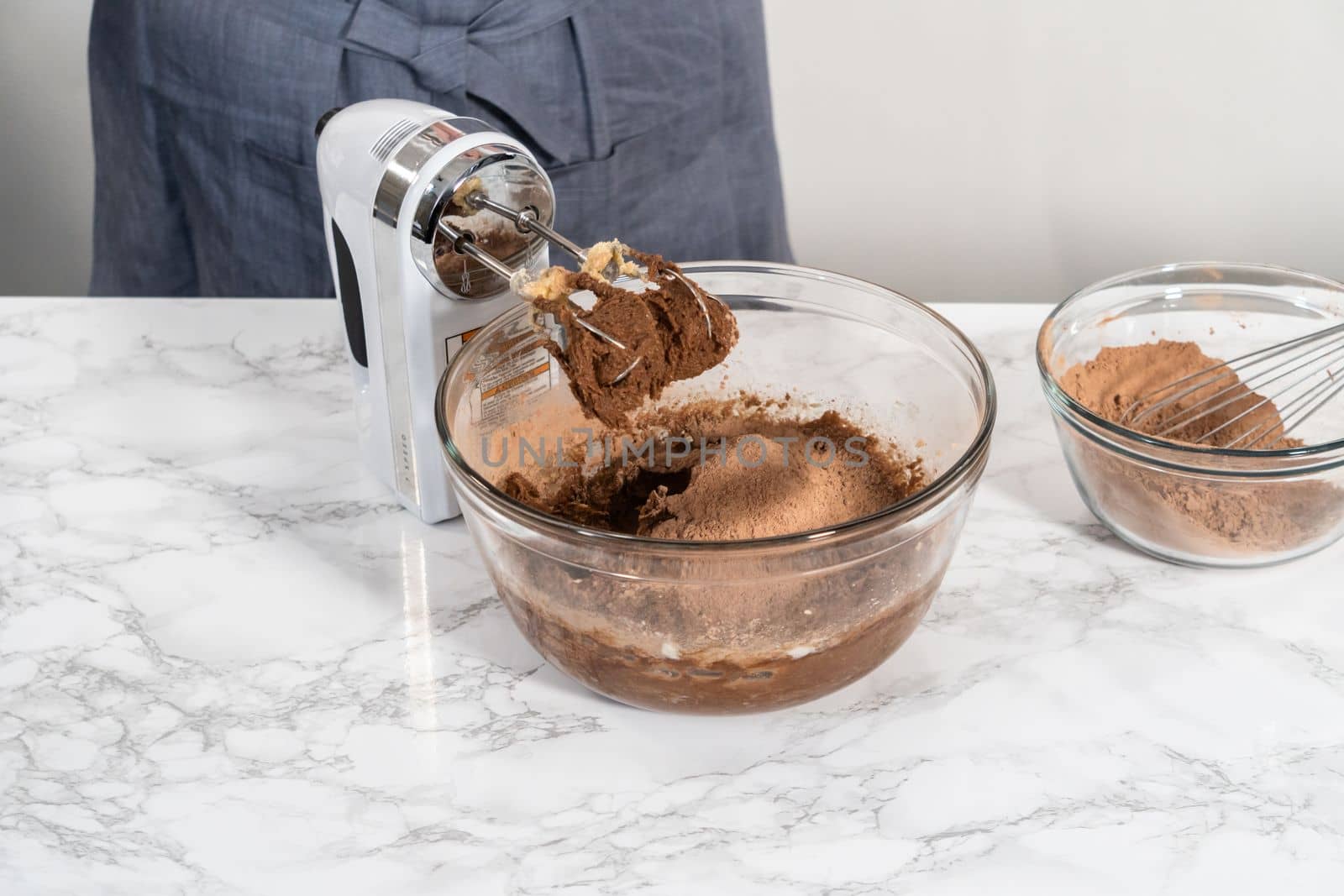 Mixing ingredients with a hand mixer to bake chocolate cookies with chocolate hearts for Valentine's Day.