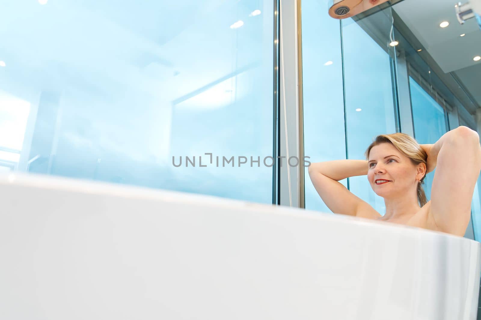 woman in freestanding white bath. Modern bathroom interior design. Beauty, healthy lifestyle concept. panoramic bathroom interior