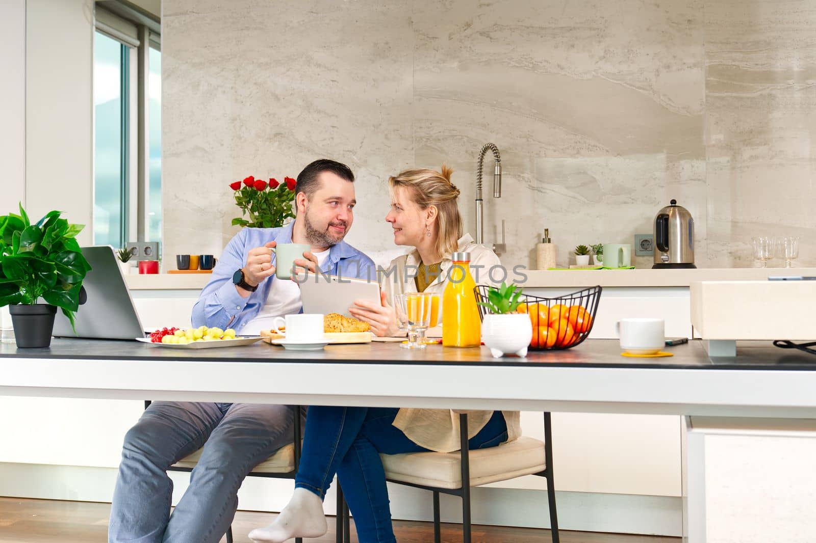 Happy couple working from home and having breakfast together. Breakfast together before leaving for work. by PhotoTime