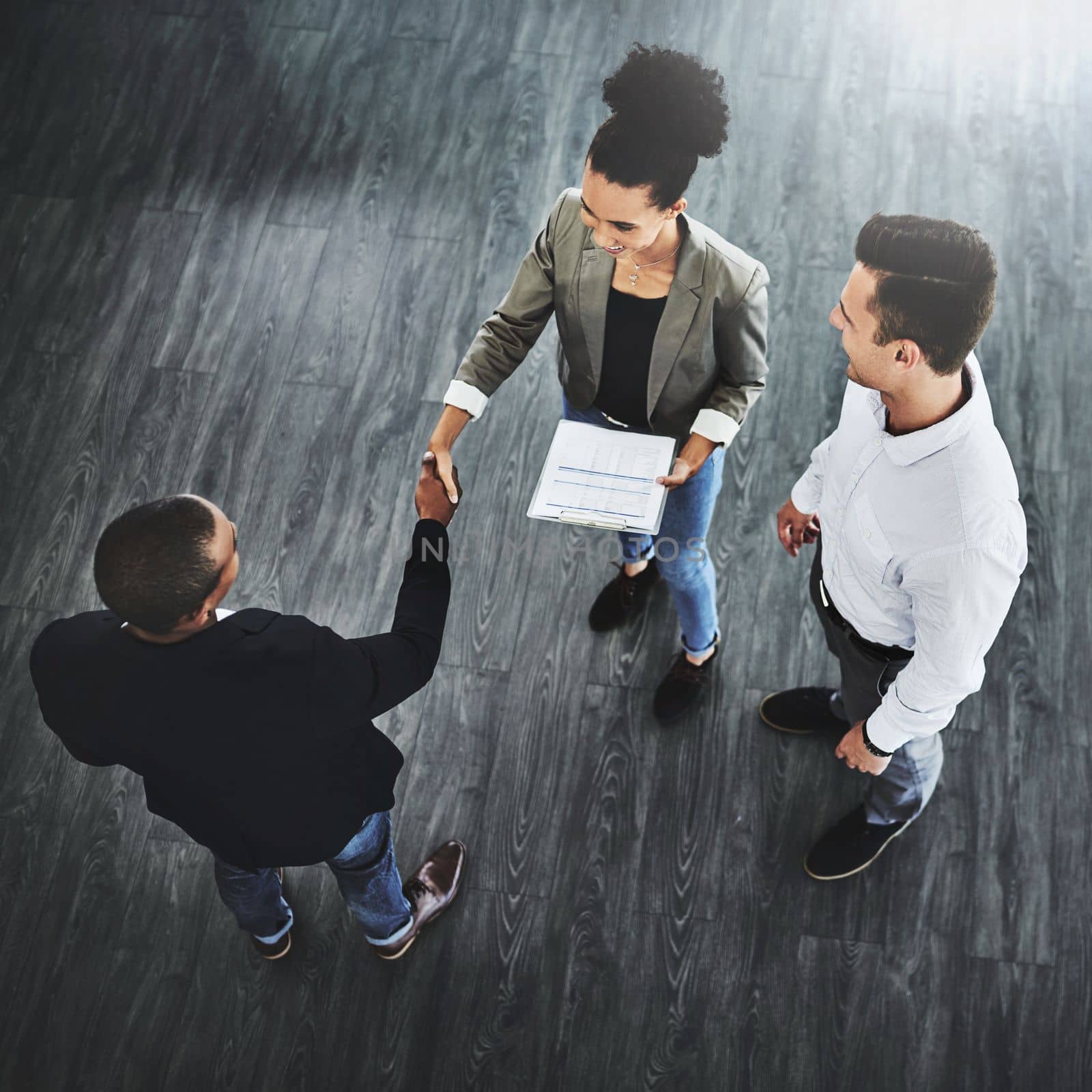 Network to let more people know about your business. High angle shot of two businesspeople shaking hands in an office. by YuriArcurs