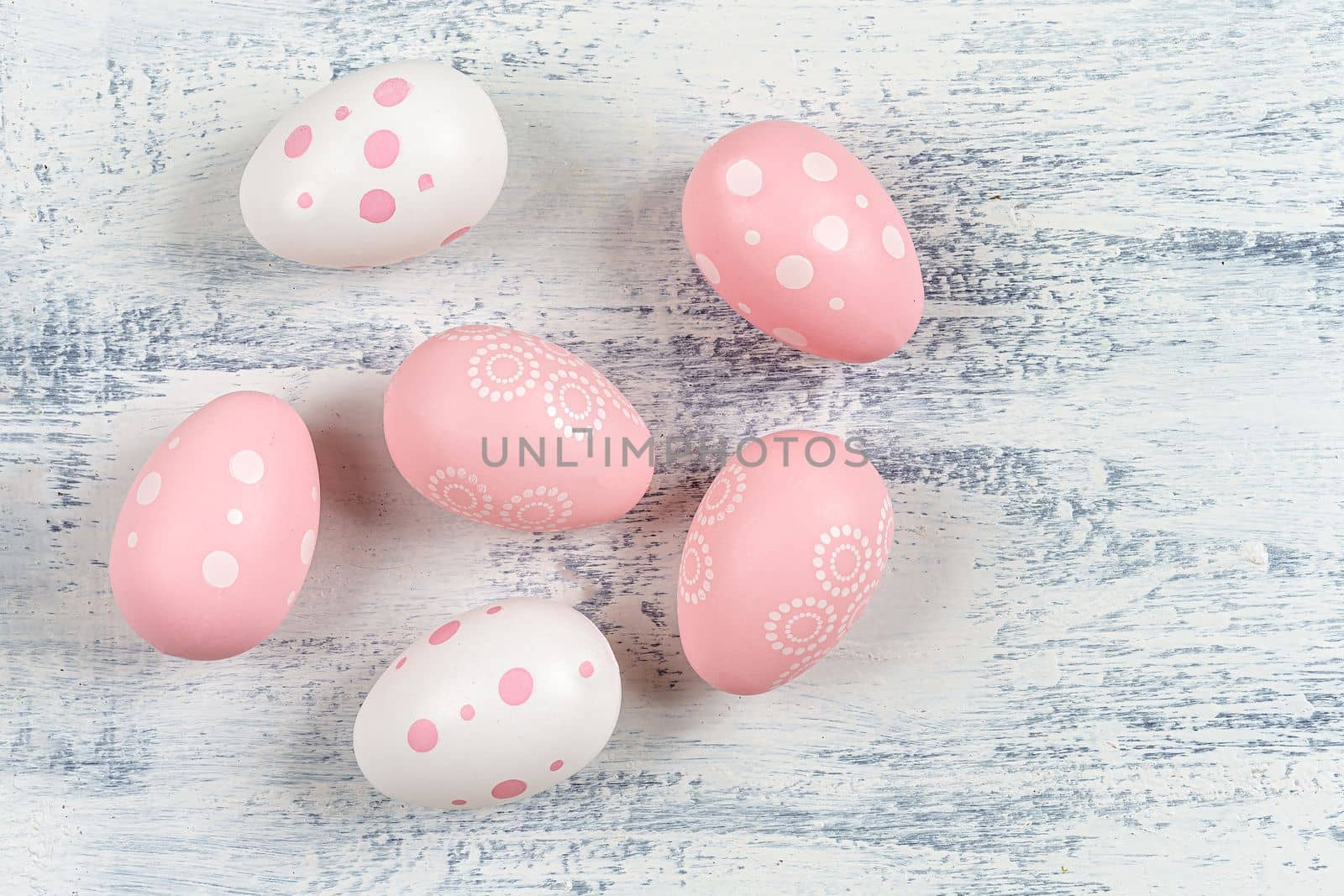 Many painted easter eggs on white wooden background. by JPC-PROD