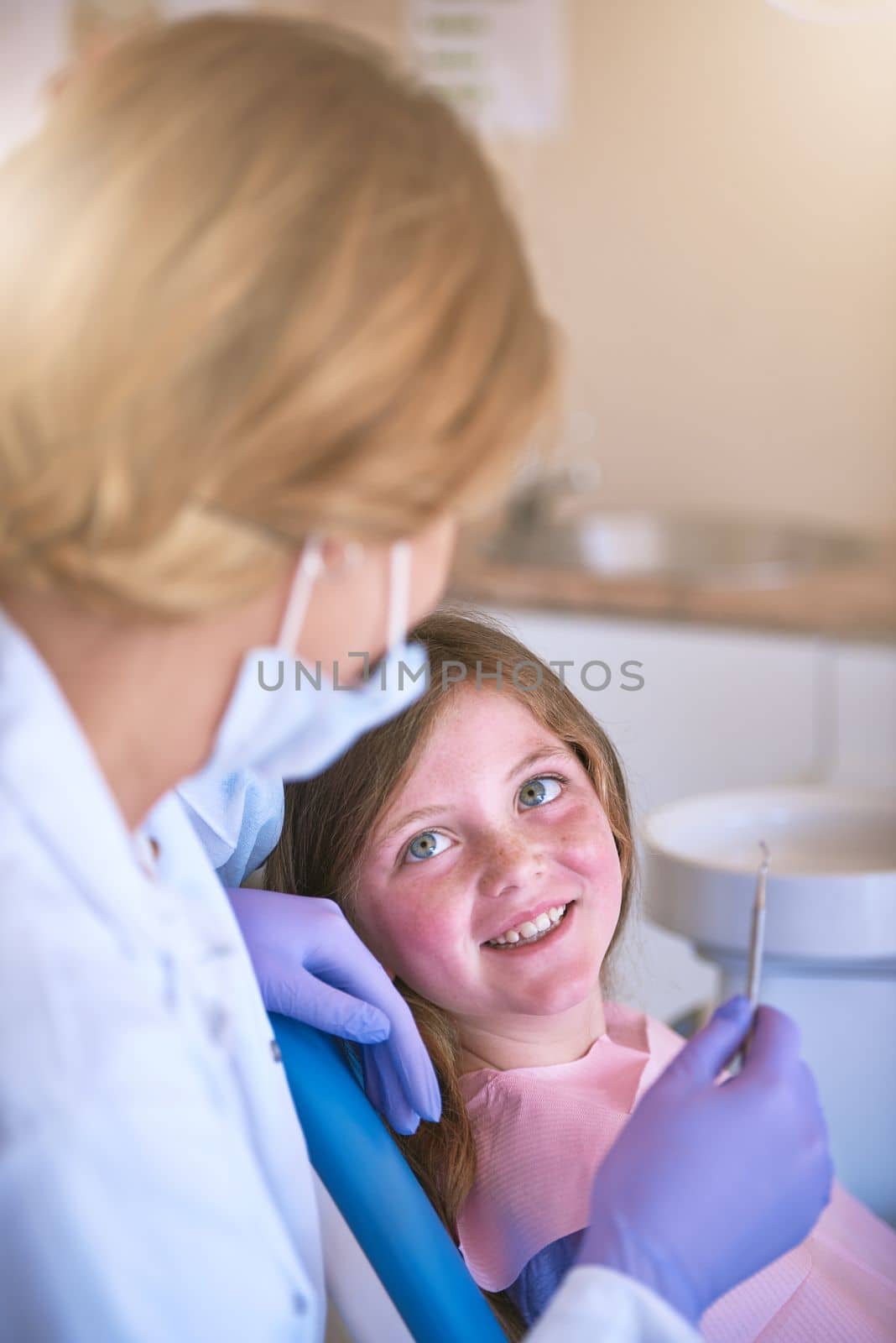 Your smile is in safe hands. a dentist examining a little girls teeth. by YuriArcurs