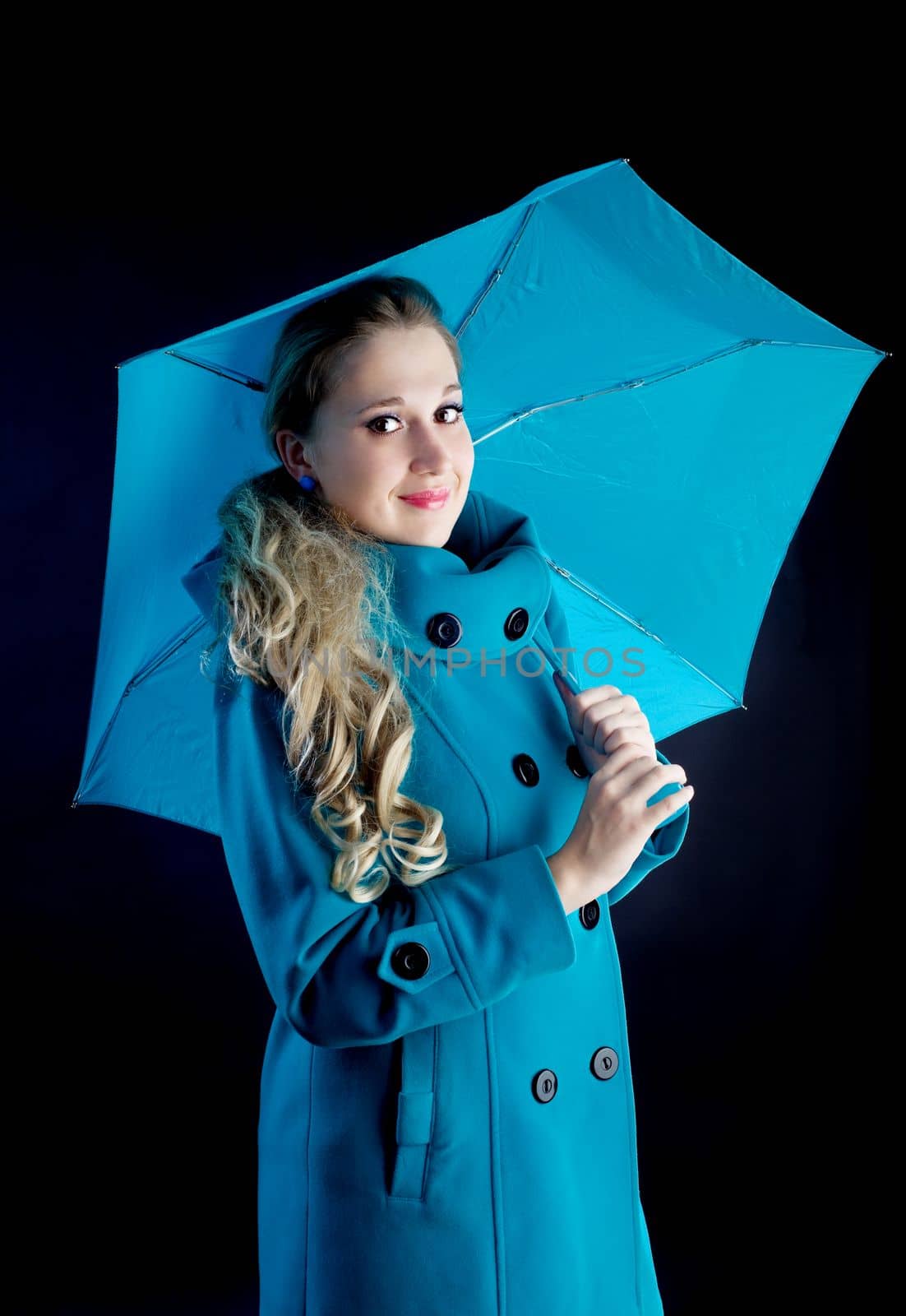 young girl in coat with blue umbrella