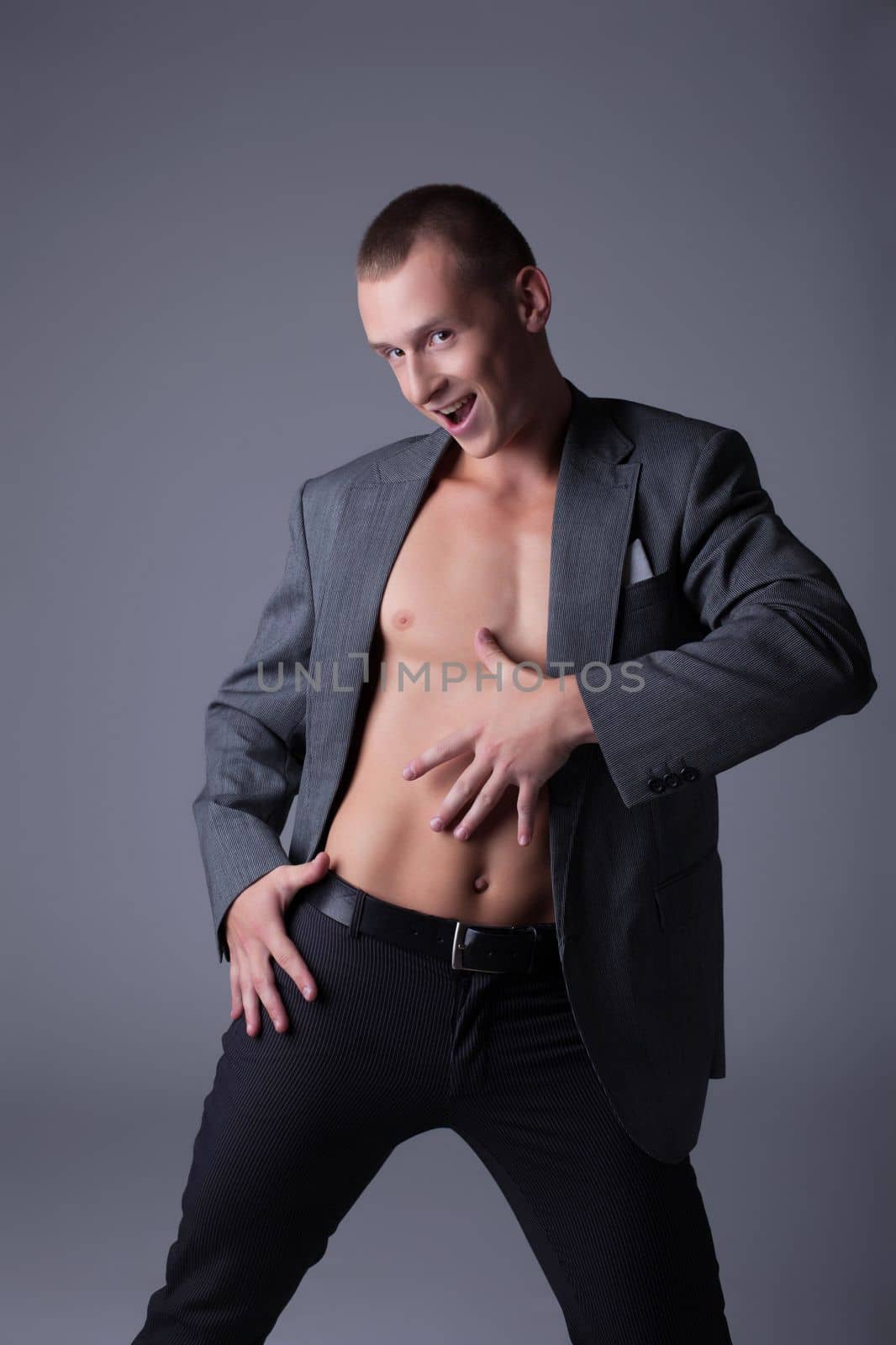 Playful young man posing in studio on gray background