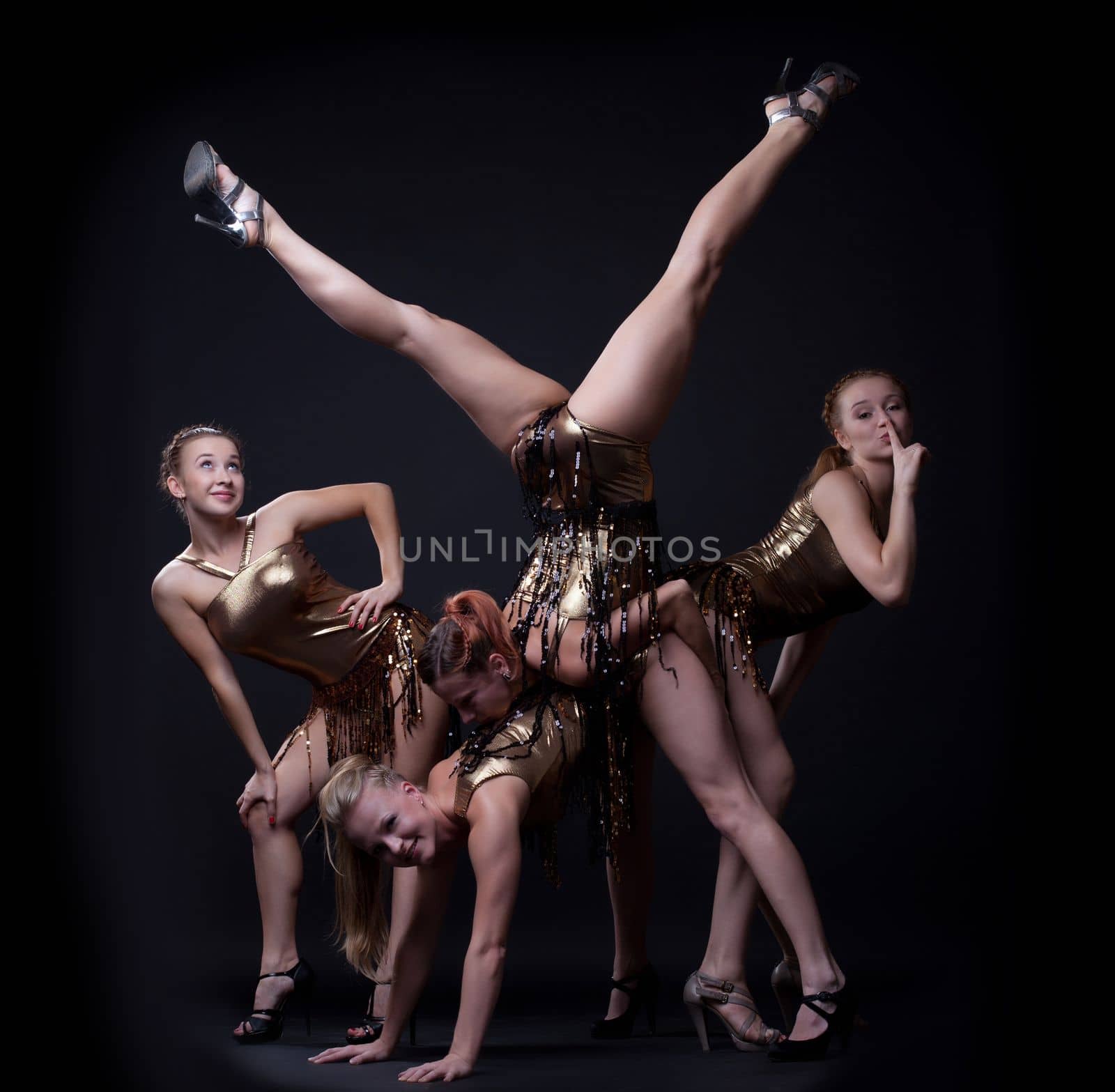 Group of women go-go dancers posing in gold costume
