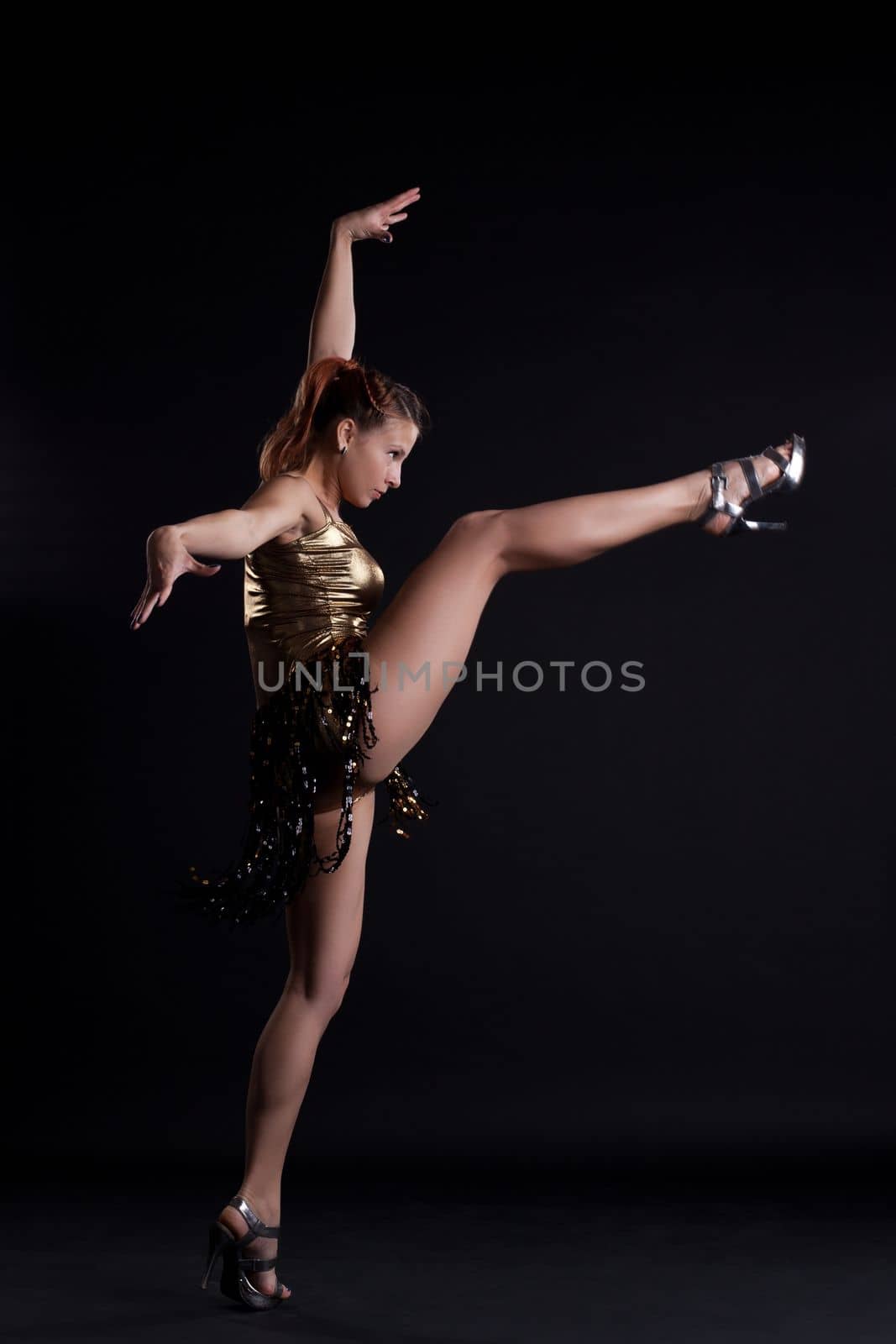 Beauty woman in gold costume show spit in dark