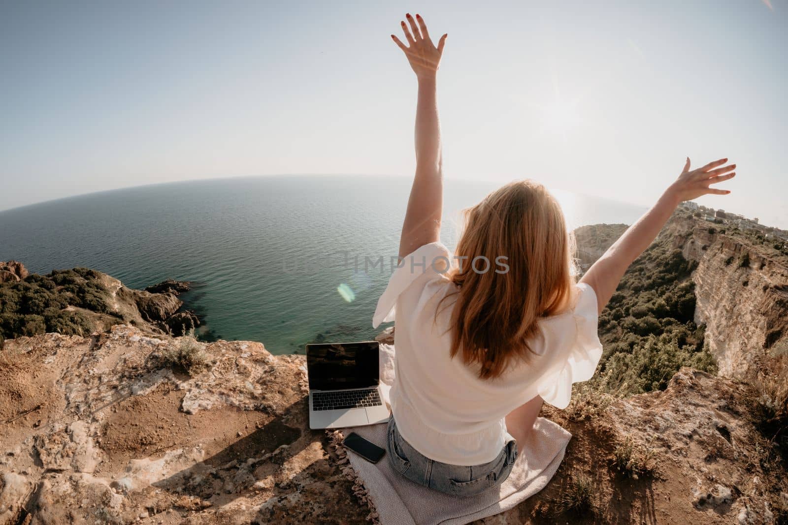 Woman sea laptop. Business woman in yellow hat working on laptop by sea. Close up on hands of pretty lady typing on computer outdoors summer day. Freelance, digital nomad, travel and holidays concept.