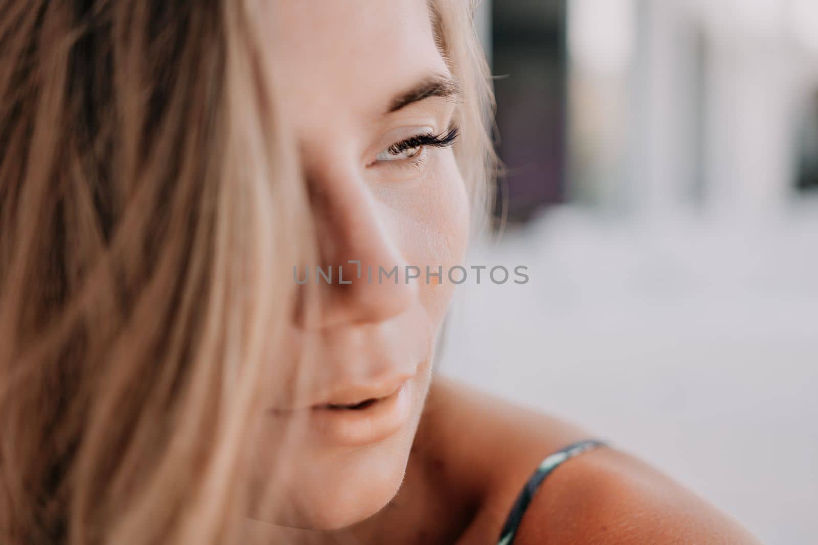 Happy woman portrait in cafe. Boho chic fashion style. Outdoor photo of young happy woman with long hair, sunny weather outdoors sitting in modern cafe