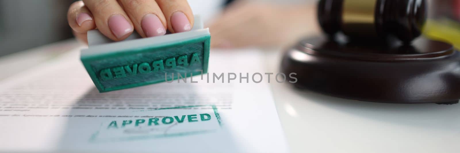 Business woman puts an approved seal on a closeup of document by kuprevich