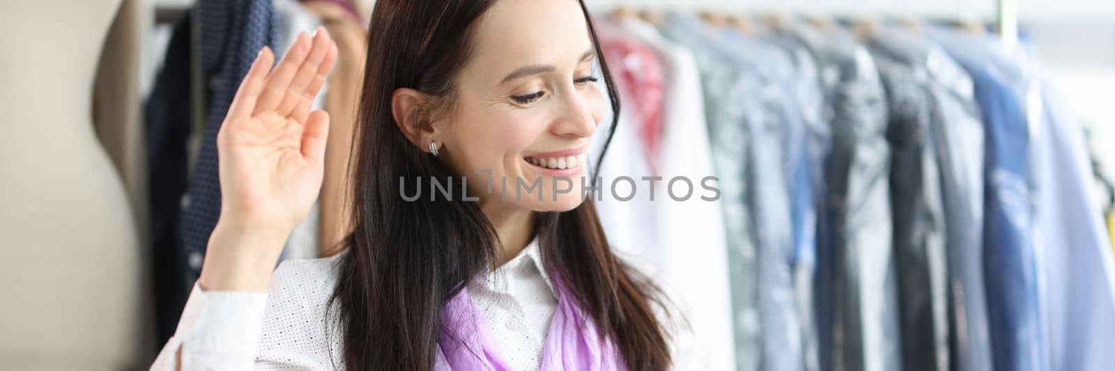 Smiling female designer or seamstress talking on webcam while giving online consultation to client. by kuprevich