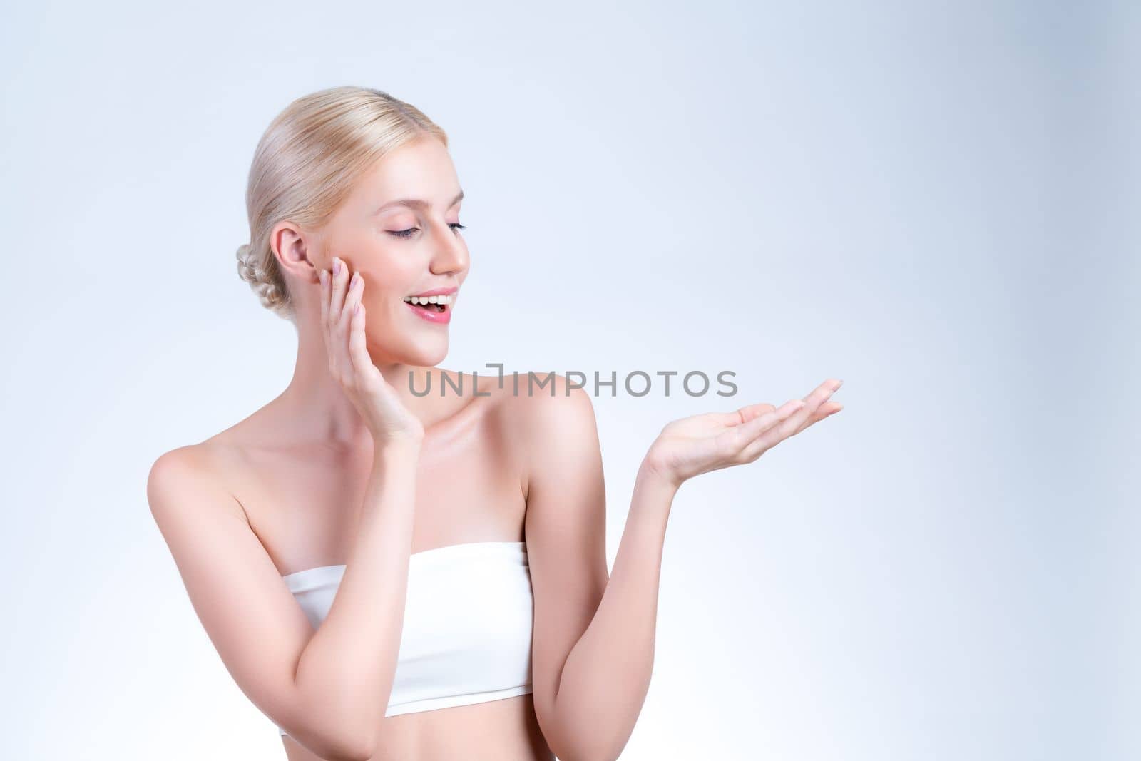 Personable beautiful woman with perfect smooth and clean skin portrait in isolated background. Beauty hand gesture with expressive facial expression for skincare treatment product or spa.