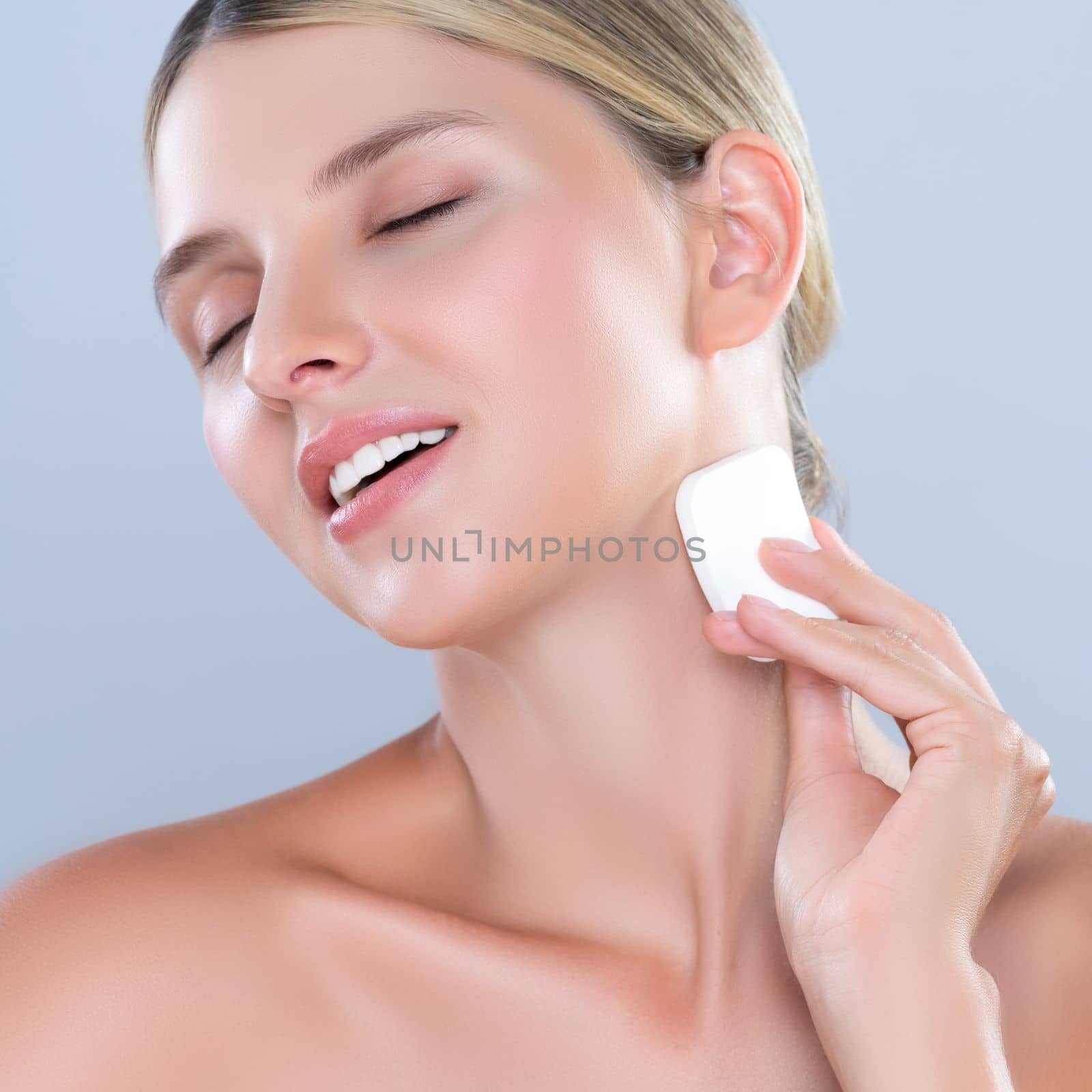 Closeup alluring beautiful female model applying powder puff for facial makeup concept. Portrait of flawless perfect cosmetic skin woman put powder foundation on her face in isolated background.
