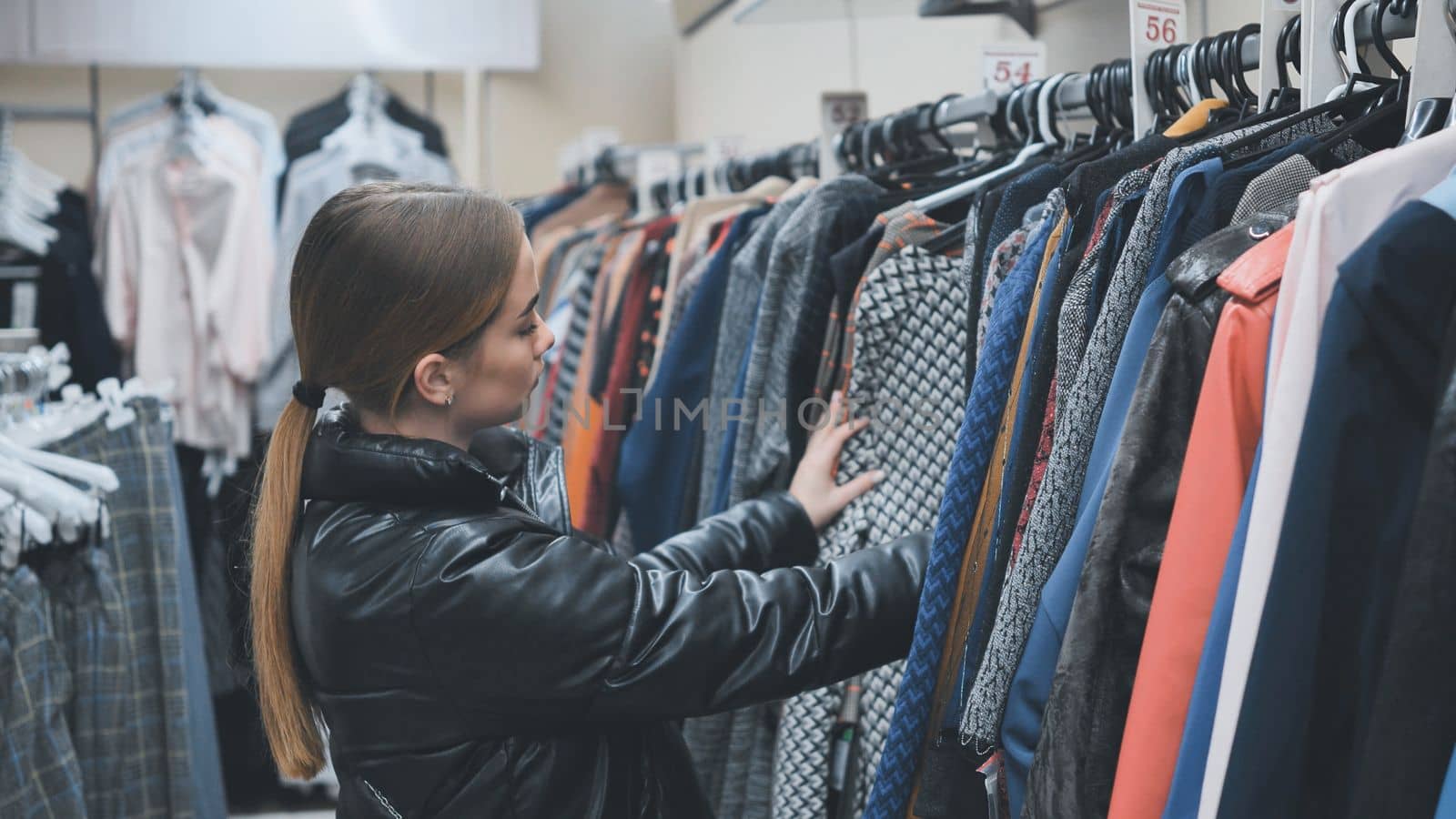 A young girl choosing and looking at clothes in the store