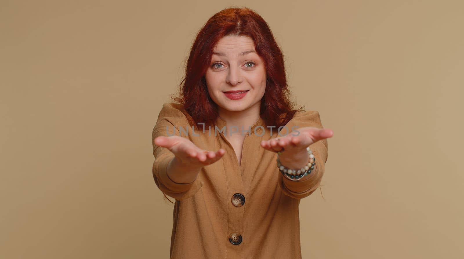 Free gifts and presents for you. Redhead woman opening hands, glad to see, excitement, preparing surprise, sharing love emotions, congratulating. Young ginger girl isolated on beige studio background
