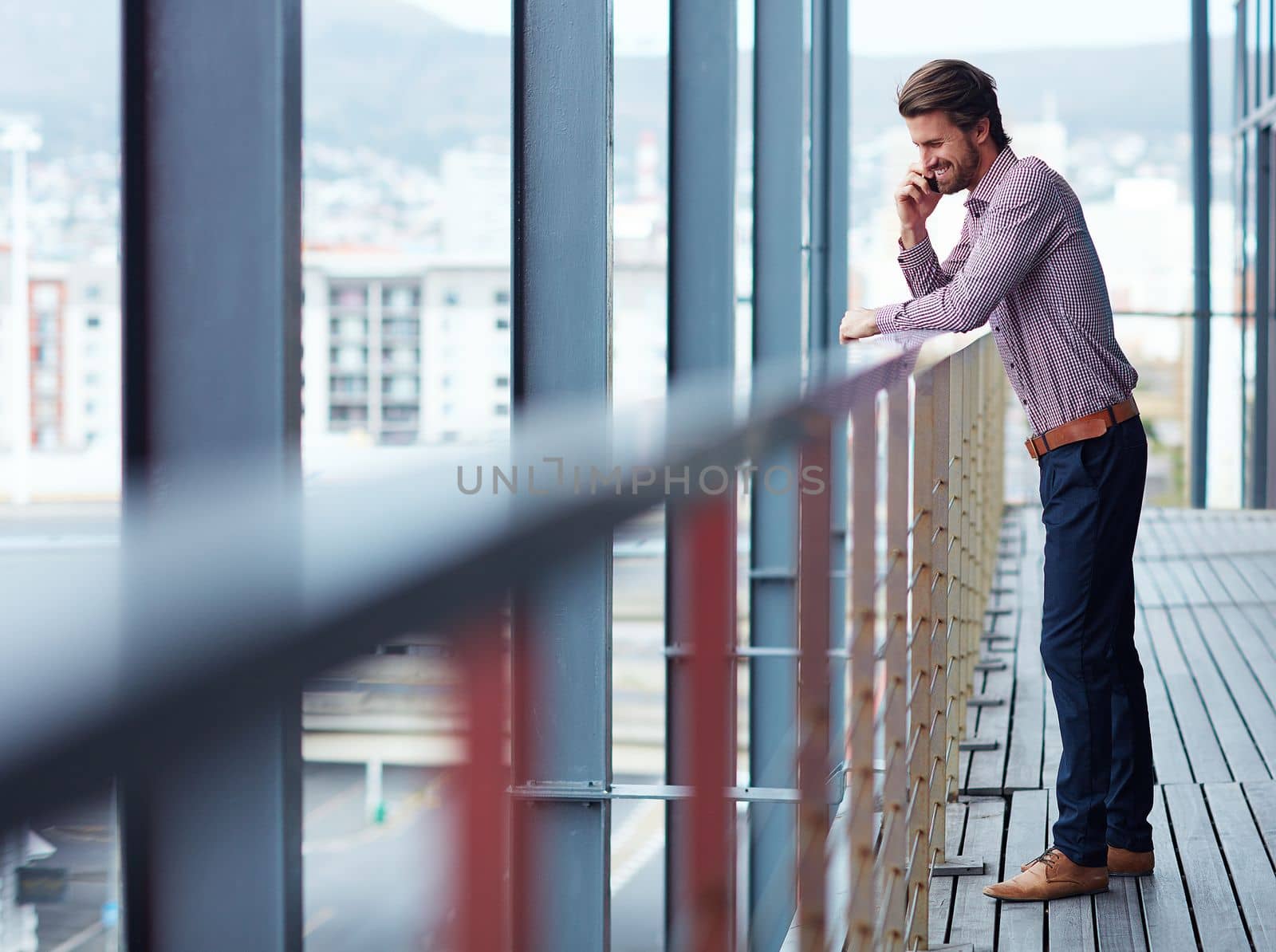 Effective communication makes for effortless business. a young businessman talking on a phone outside of an office building. by YuriArcurs