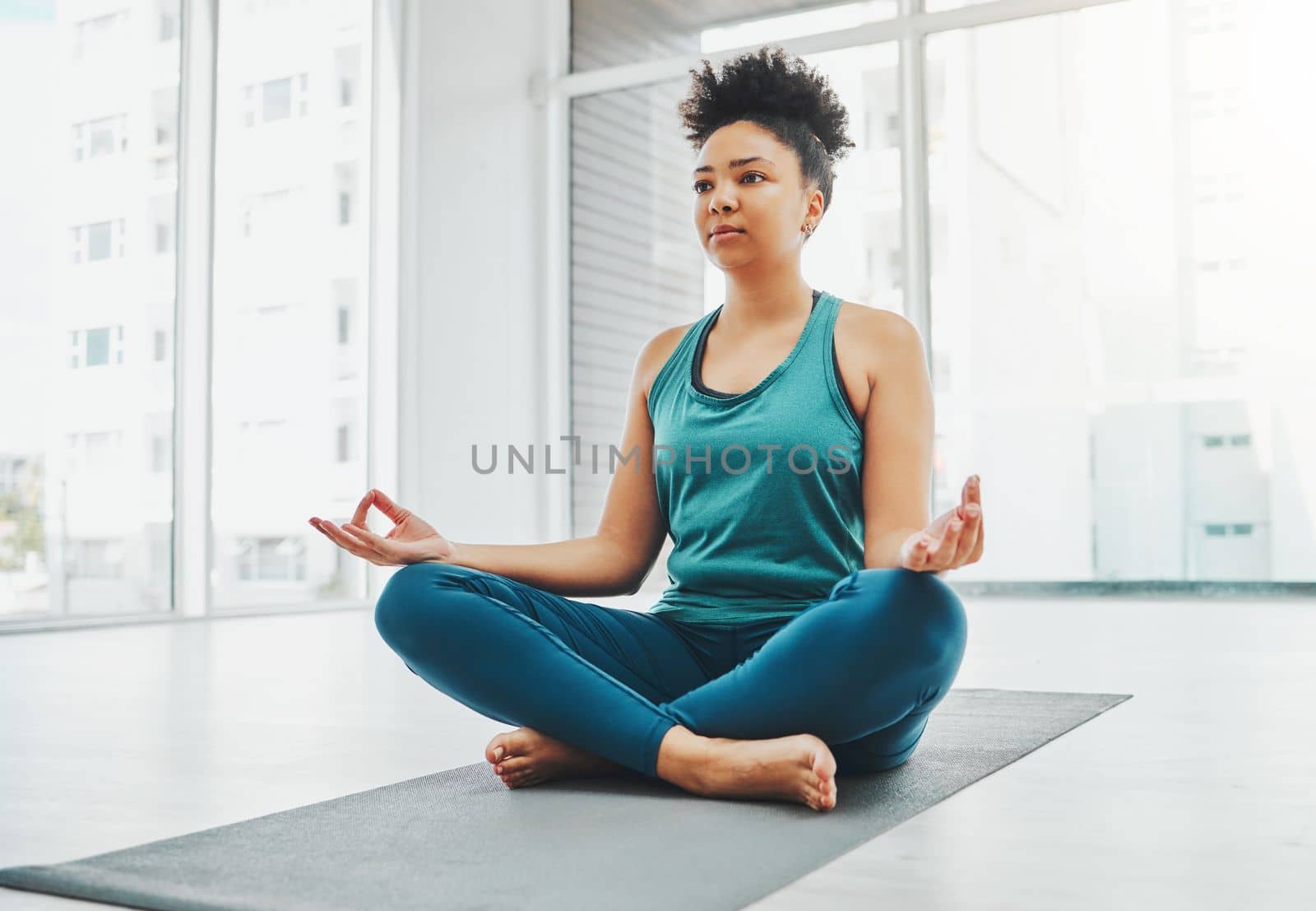 Yoga, black woman and meditation with lotus exercise for fitness, peace and wellness. Young person in health studio for holistic workout, mental health and body balance with zen energy to relax by YuriArcurs