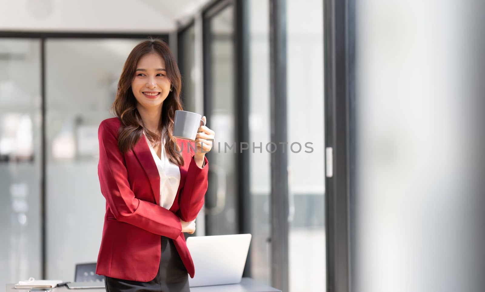 Businesswoman entrepreneur or an office worker stands with near a desk in a office.