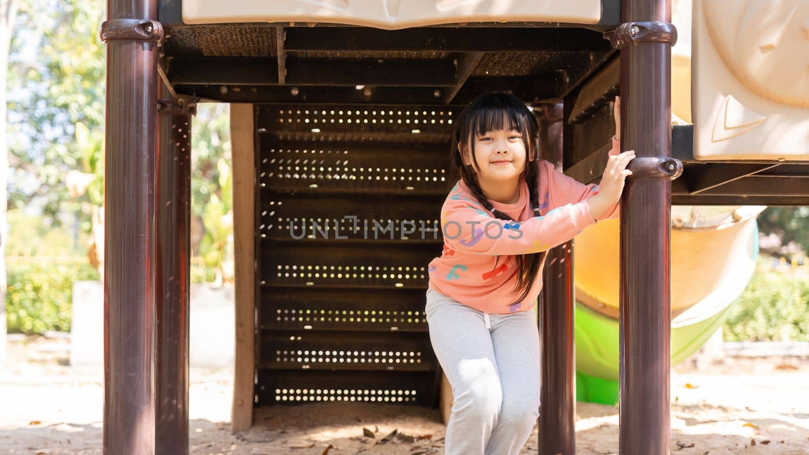 Happy children girl playing and having fun at the playground by nateemee