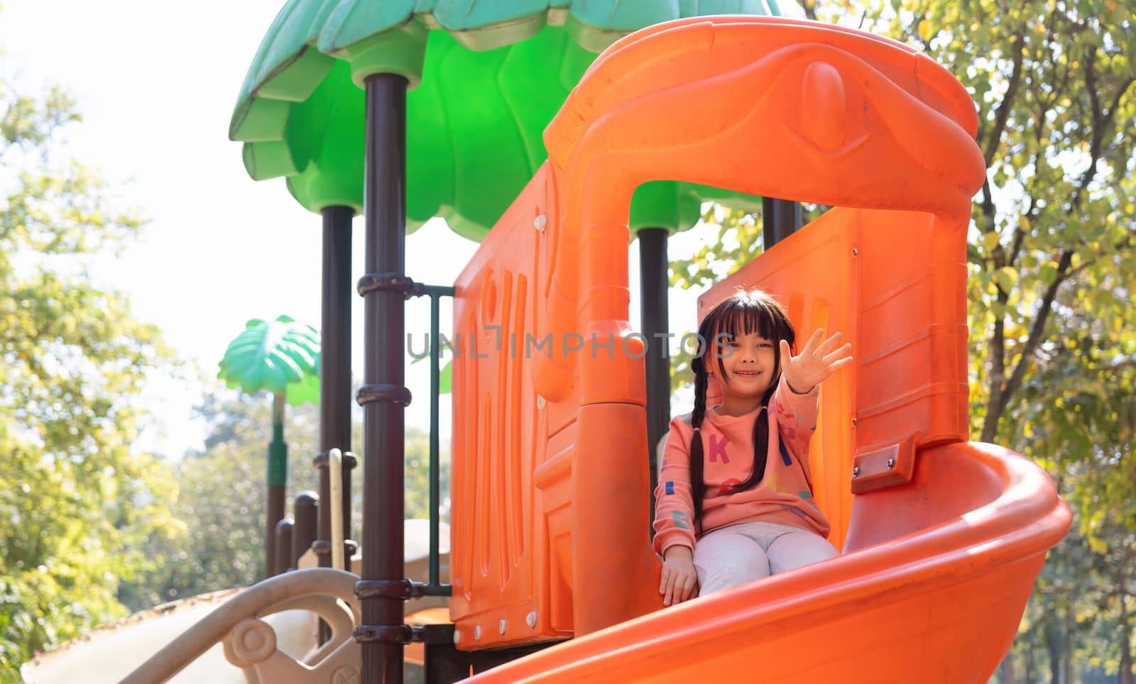 Happy children girl playing and having fun at the playground by nateemee