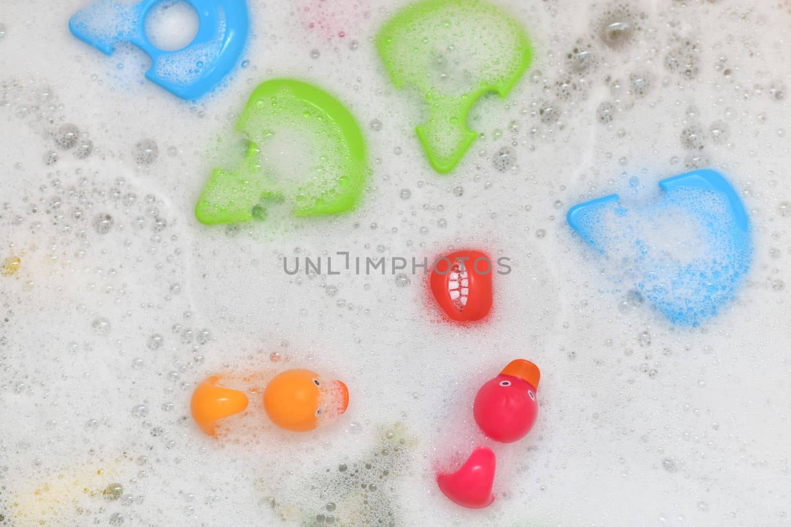 Rubber multicolored toys in a bubble bath for a baby