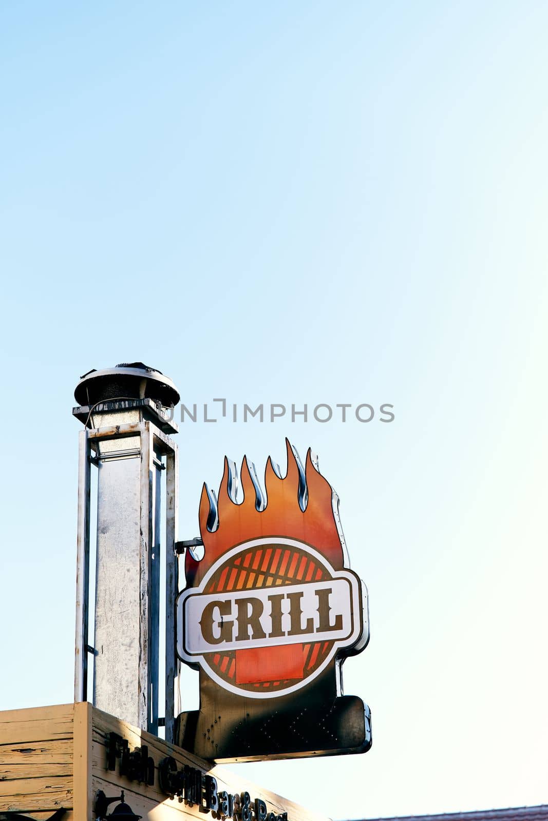 Nameplate affixed to the chimney on the roof of the building. Grill lettering. Close-up. High quality photo