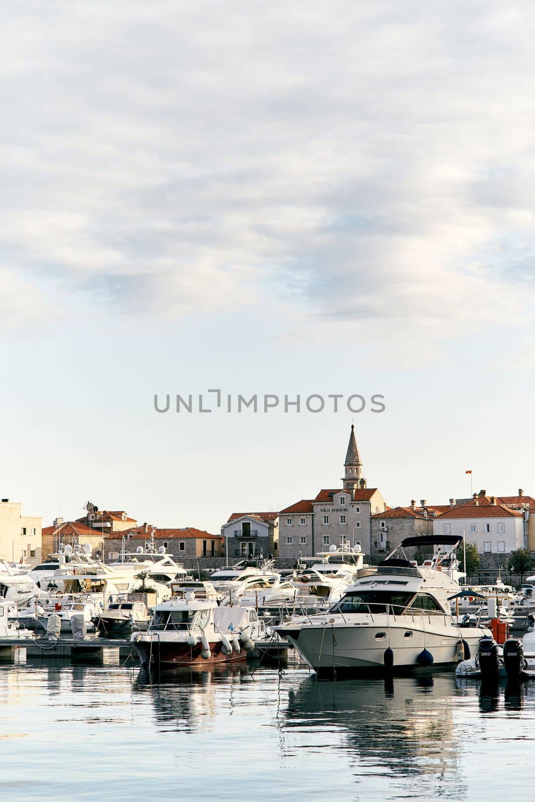 A pier with white yachts against the background of ancient houses and a beautiful cloudy sky. High quality photo