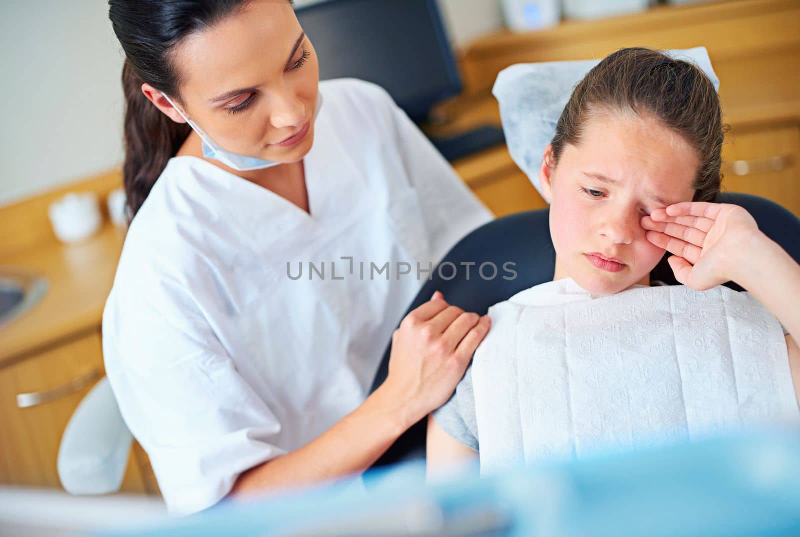 Its only one cavity. a crying little girl sitting in a dentists chair