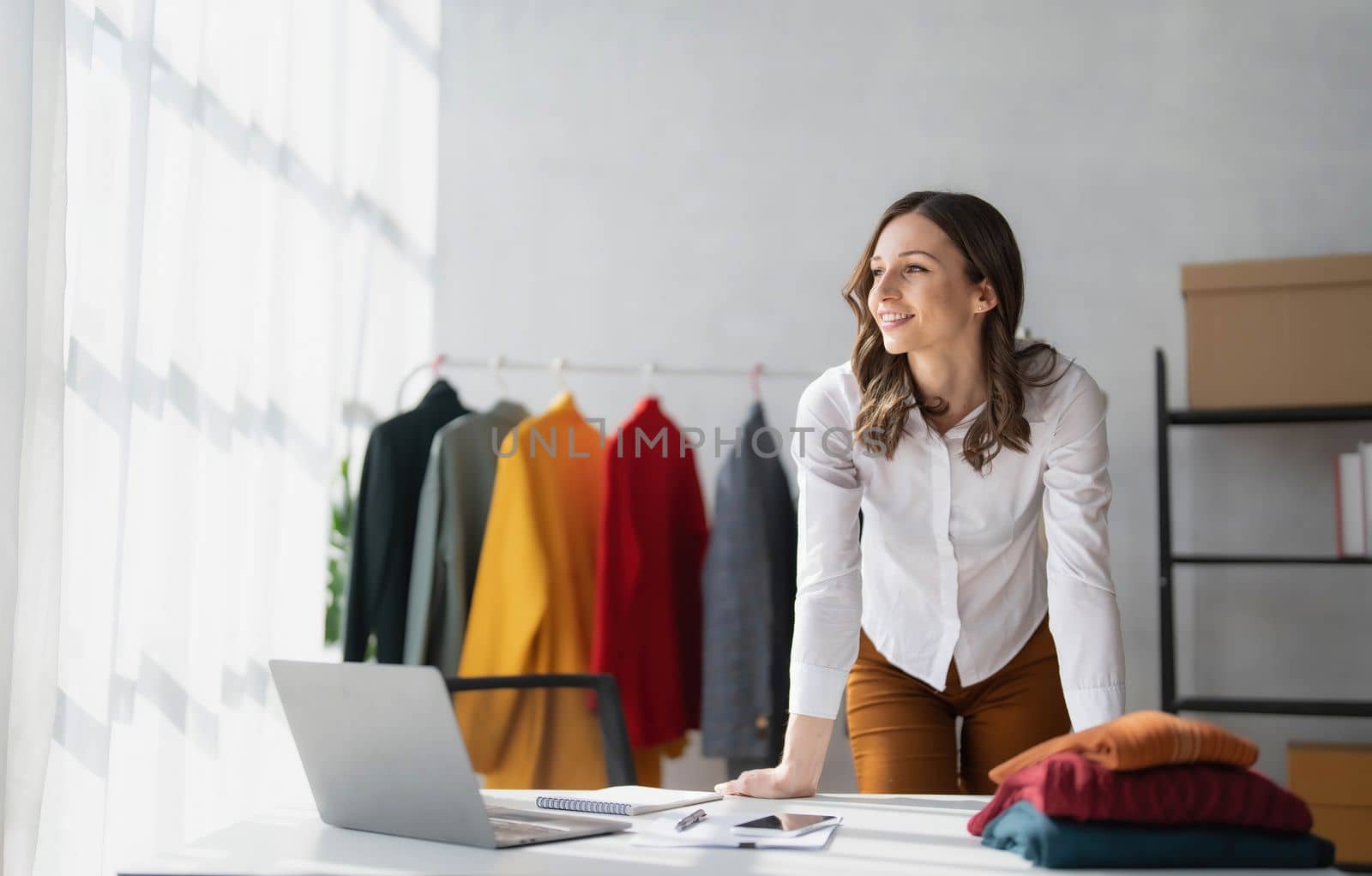 Portrait of young beautiful asian woman fashion designer stylish stand and working with color samples.Attractive young asian girl working with colorful fabrics at fashion studio..