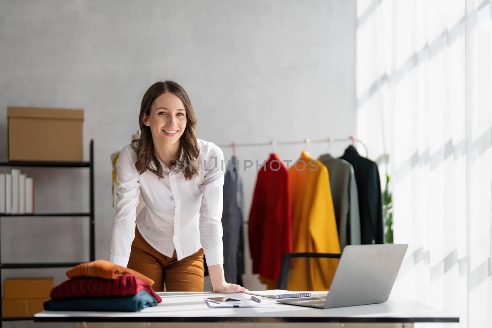 Portrait of young beautiful asian woman fashion designer stylish stand and working with color samples.Attractive young asian girl working with colorful fabrics at fashion studio by wichayada