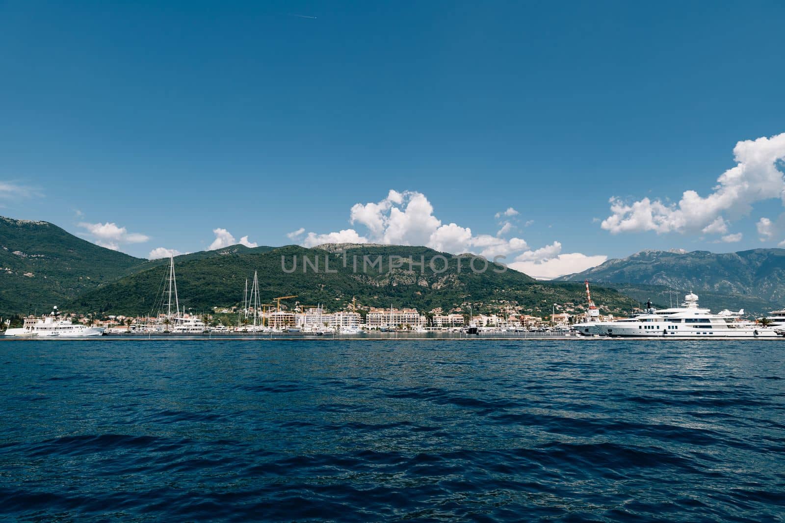 White yacht sails to the coast of the expensive resort of Porto. Montenegro. High quality photo