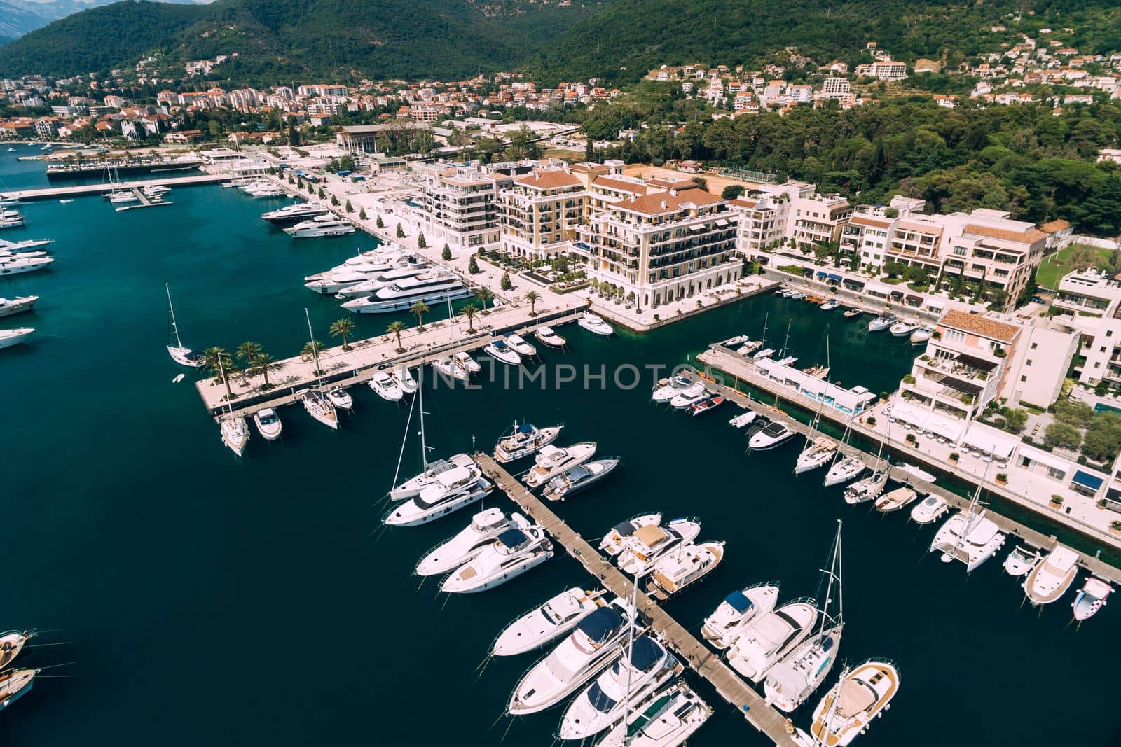 Aerial view of moored yachts near the modern buildings of the Porto resort. Montenegro. High quality photo