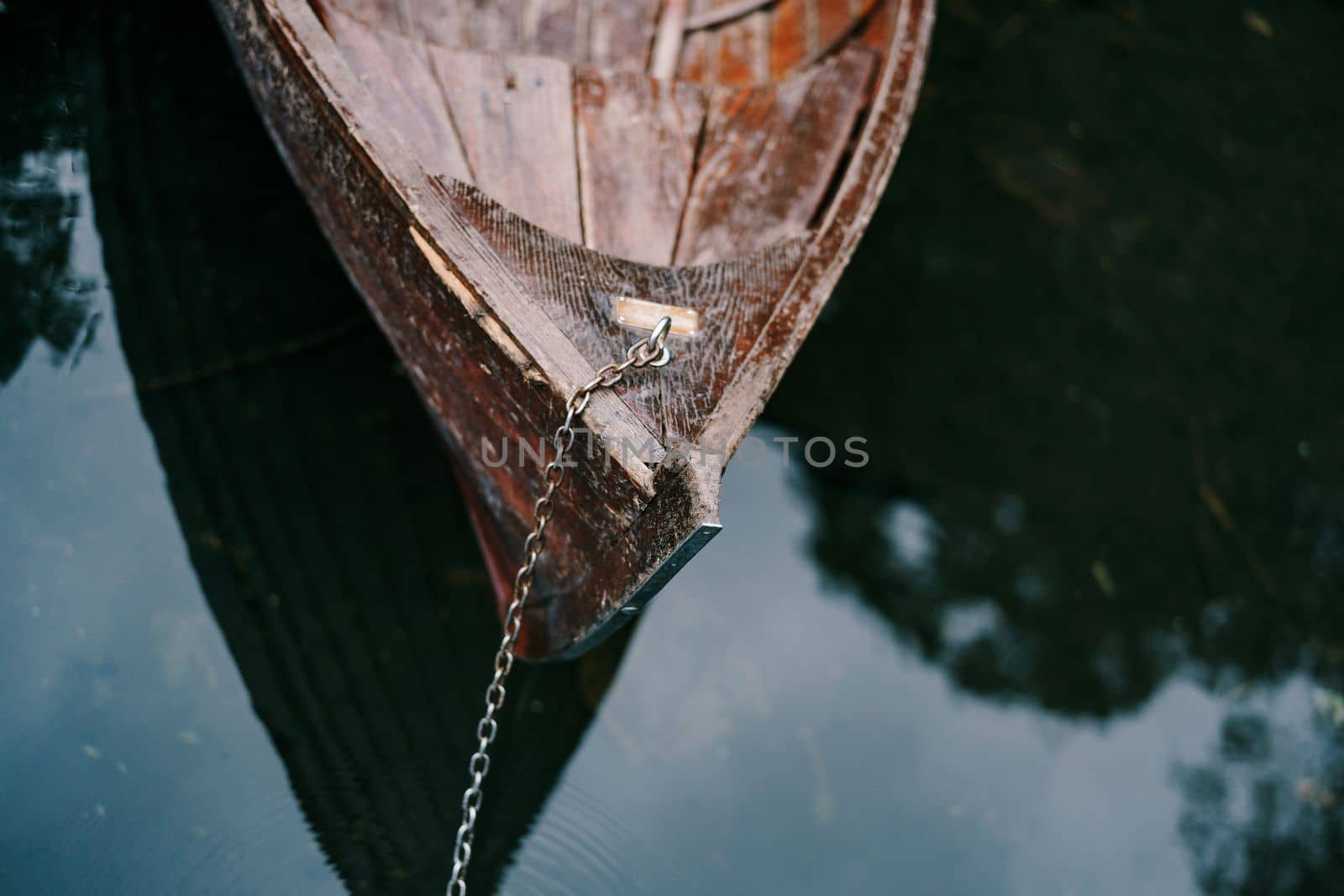 Boat is moored with a metal chain at the stern on the lake. Biogradska Gora, Montenegro. High quality photo