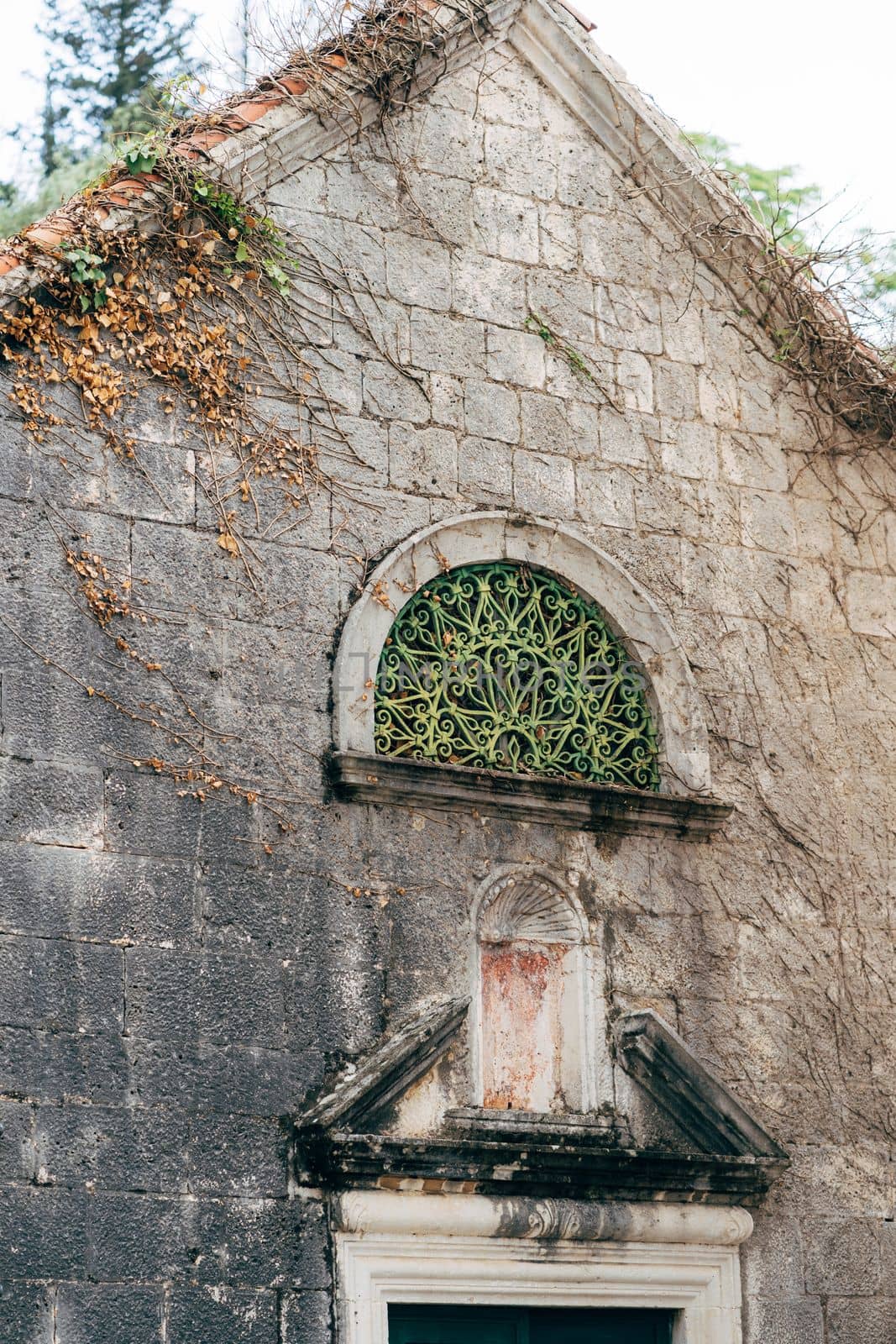 Old stone wall of a building with an arched window. Perast, Montenegro. High quality photo