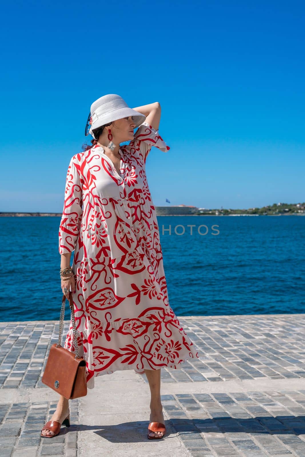 woman in a hat and dress enjoys the blue sea and summer. Welcome summer. by Matiunina