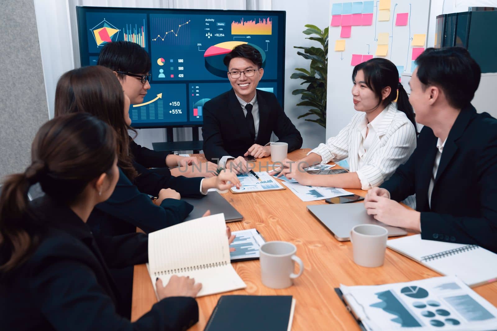 Business team of financial data analysis meeting with business intelligence, report paper and dashboard on laptop for marketing strategy. Business people working together to promote harmony in office.