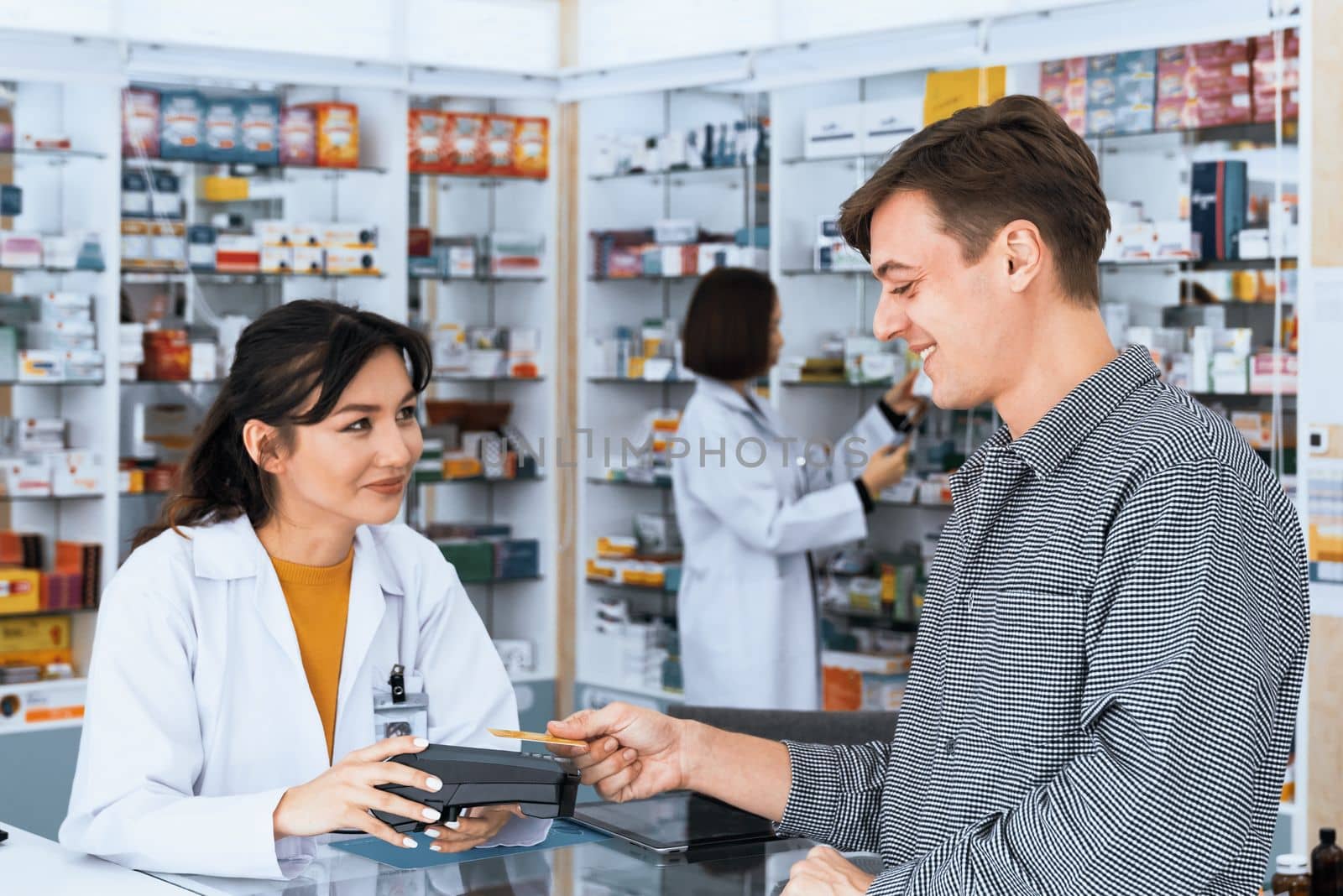 Caucasian customer purchases qualified prescription medication from pharmacist. by biancoblue