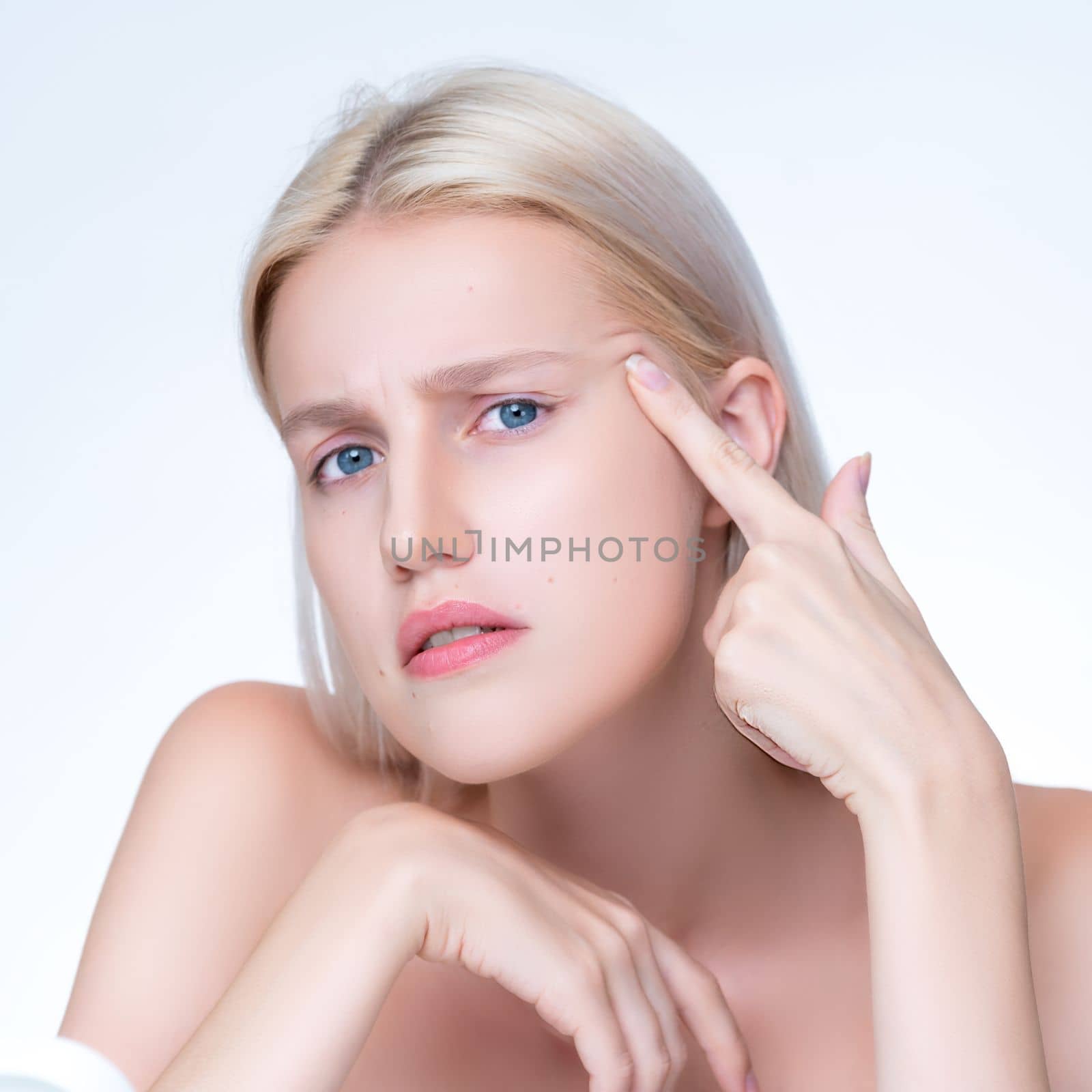 Acne problem troubling closeup personable worried woman with natural beauty skin checking her face squeezing pimple spots in isolated background. Copyspace for blemish skincare treatment problem.