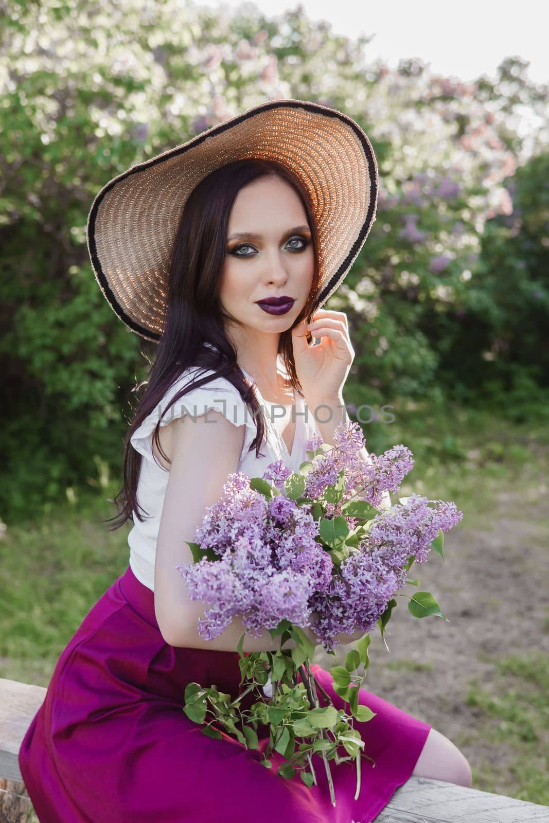 A fashionable girl with dark hair, a spring portrait in lilac tones in summer. Bright professional makeup