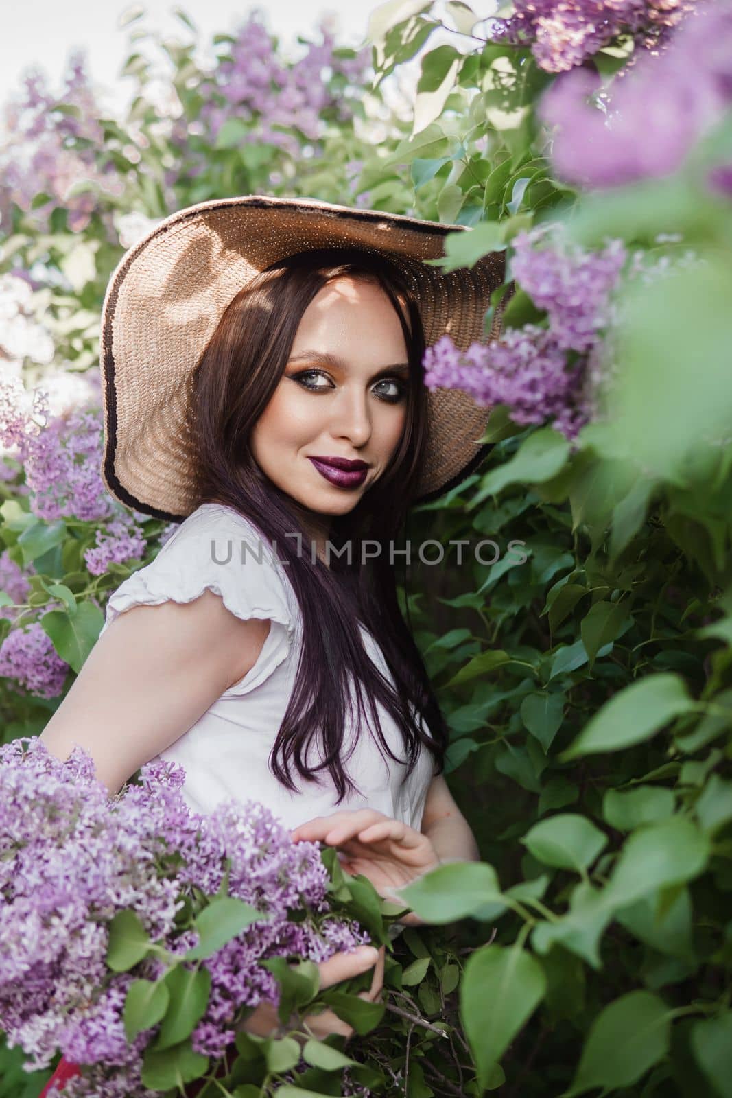 A fashionable girl with dark hair, a spring portrait in lilac tones in summer. Bright professional makeup