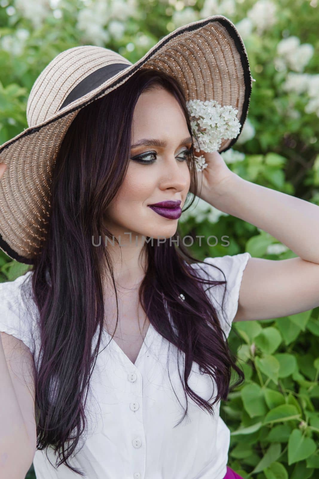 A fashionable girl with dark hair, a spring portrait in lilac tones in summer. Bright professional makeup