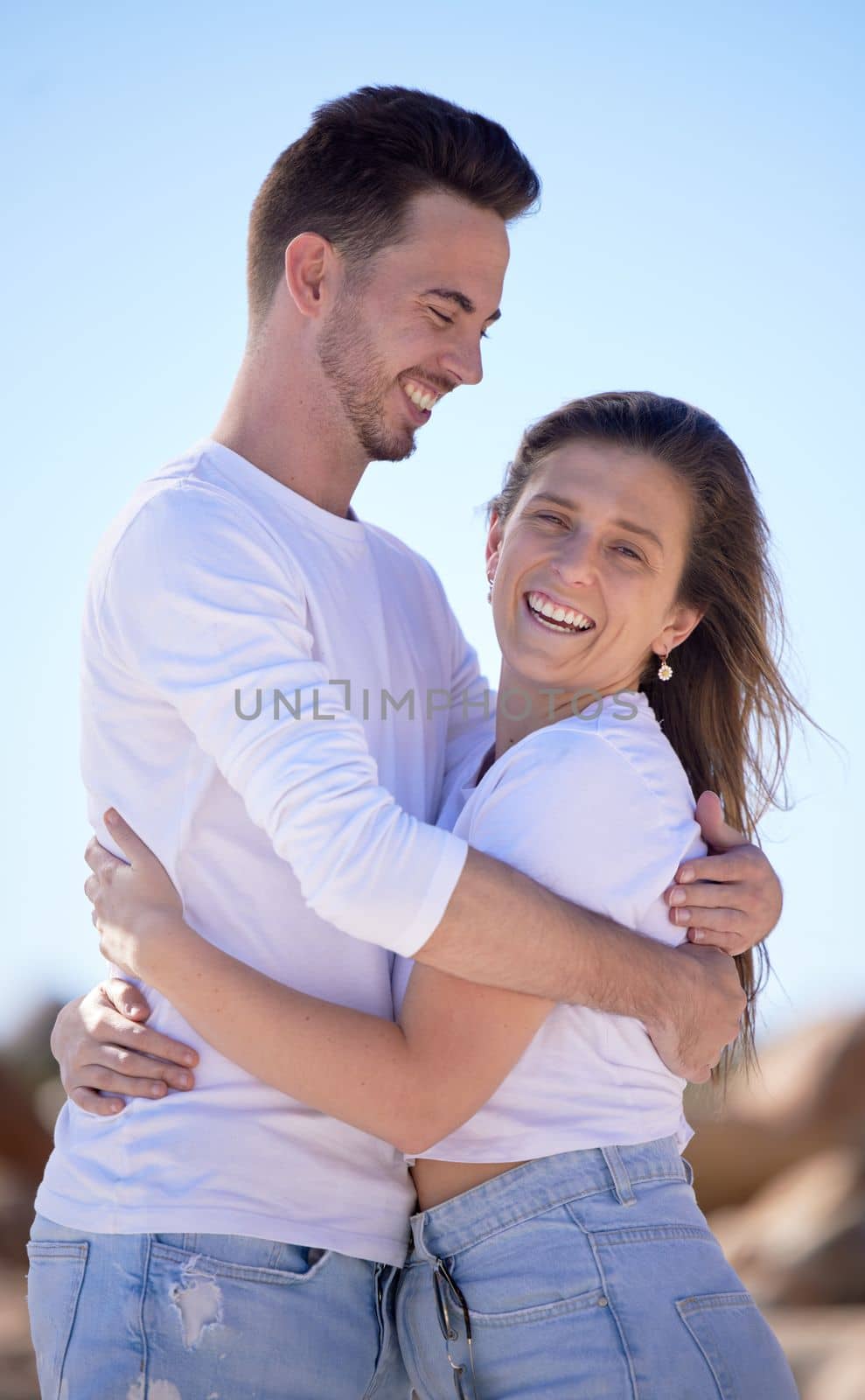 Portrait, couple love and hug at beach and happy with smile for relationship, romantic date or vacation together. Romance, man and woman with happiness, summer and embrace for travel or holiday.