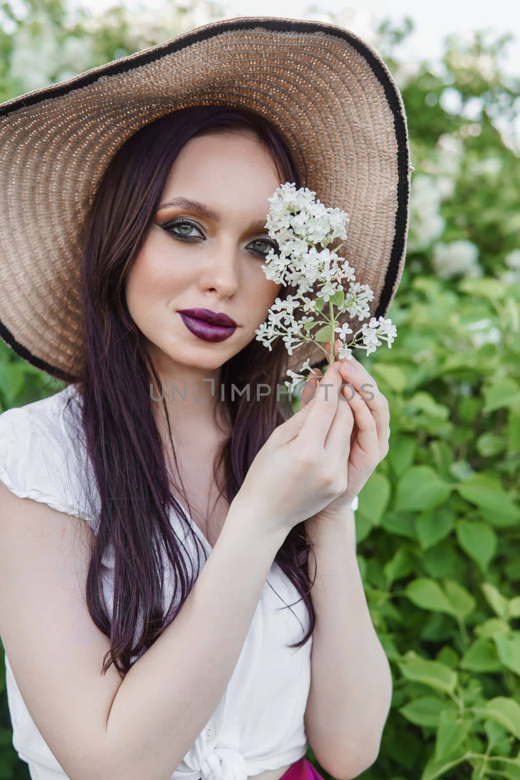 A fashionable girl with dark hair, a spring portrait in lilac tones in summer. Bright professional makeup
