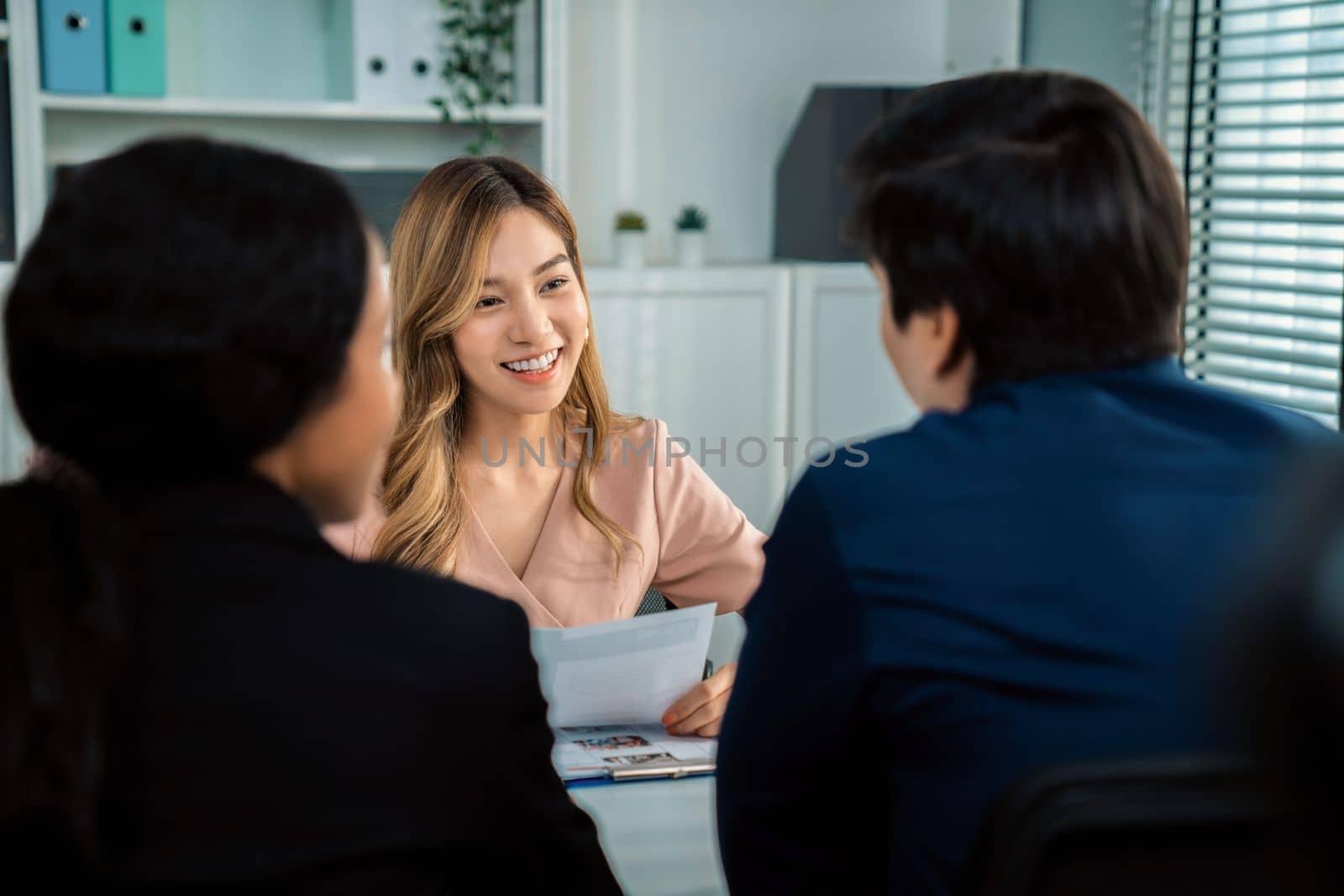 A young female asian candidate tries to impress her interviewer by being competent. International company, multicultural environment in workplace.